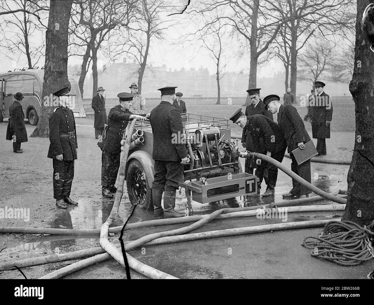 Die Londoner Feuerwehrleute haben einen Luftangriffsbohrer mit neuer Pumpe. Feuerwehrleute führen nun regelmäßige Bohrarbeiten mit den Regierungspumpen in Battersea Park, Victoria Park und Hyde Park durch, als Teil der Luftangriffsvorsorgearbeit der Londoner Feuerwehr, für die nun eine spezielle Abteilung in der Brigade eingerichtet wurde. Das Pumpen von Wasser über große Entfernungen wird einer der wichtigsten Faktoren im Falle von Überfällen sein, wenn die Leitungen zerstört werden könnten. Canvas Pools werden für die Wasseraufbereitung von Flusskanälen verwendet. Foto zeigt, Feuerwehrmann versucht eine neue Anhänger-Typ Wasserpumpe in Battersea Park. 3 Stockfoto