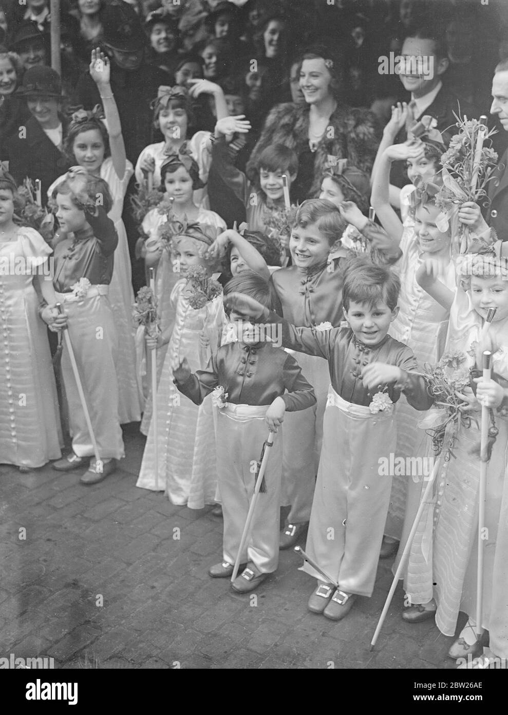 Eingang von Lady Patricia Douglas zu Graf John de Bendern. Lady Patricia Douglas, 19-jährige Tochter von Lady Dunn und der Marquess of Queensberry, wurde im Brompton Oratory mit Graf John de Brndern, Sohn von Graf und Gräfin de Bendern und britischer Amateur-Golfmeister im Jahr 1932 verheiratet. Graf John gewann die Meisterschaft als John de Forest, aber Änderungen benannt durch Tote Umfrage auf seinen Vater zu Graf von Bendern von Liechtenstein. Foto zeigt, Brautleute winken ihre weißen Stäbe mit Bündchen von roten und weißen Blumen an der Spitze, als die Braut und Bräutigam die nach Zeremonie verlassen. 27. Januar 1938 Stockfoto