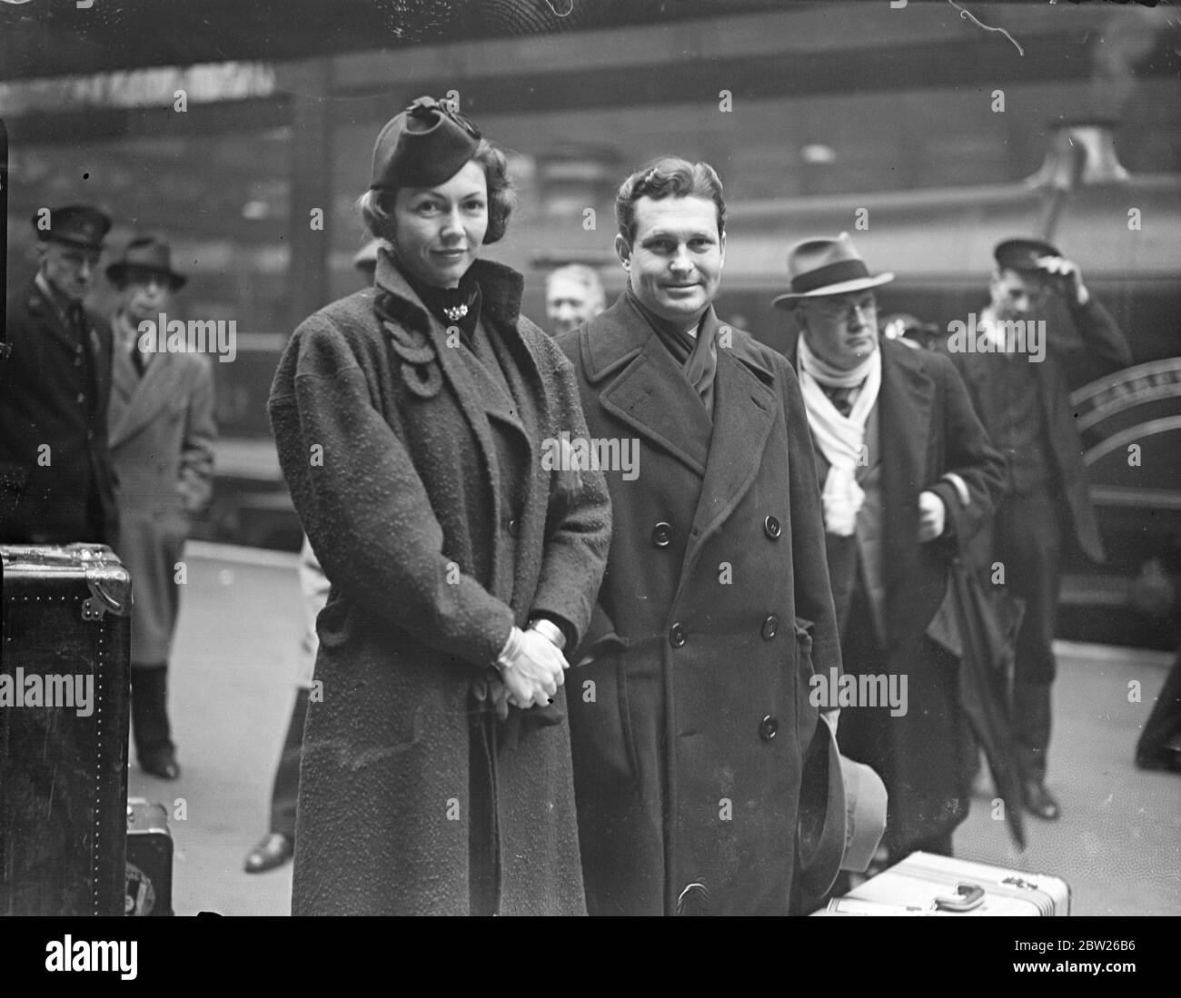 Cecil B de Milles Tochter und Ehemann kamen auf Hochzeitsreise an. Cecilia, Tochter von Cecil B de Mille, dem Filmproduzenten und ihrem Mann JW Harper, der kurz nachdem Miss de Mille sich scheiden ließ, in Chicago verheiratet war, kam mit dem 'Manhattan'-Bootszug am Bahnhof Paddington in London an, um ihre Flitterwochen zu verbringen. Februar 1938 Stockfoto