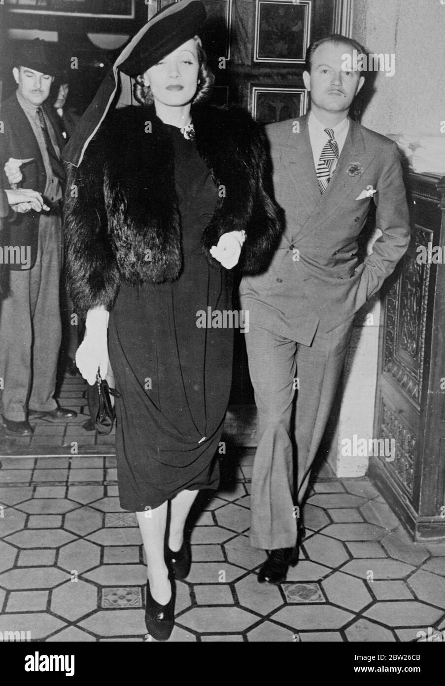 Marlene's 'Turban' Mode, bei Hollywood Premiere. Marlene Dietrich, die Filmschauspielerin, trug eine Hutschneeart und Pelze im Turban-Stil, als sie mit Andy Lowler zur Premiere der 'Goldwyn Follie' im Hollywood Theatre in Los Angeles ankam. Februar 1938 Stockfoto
