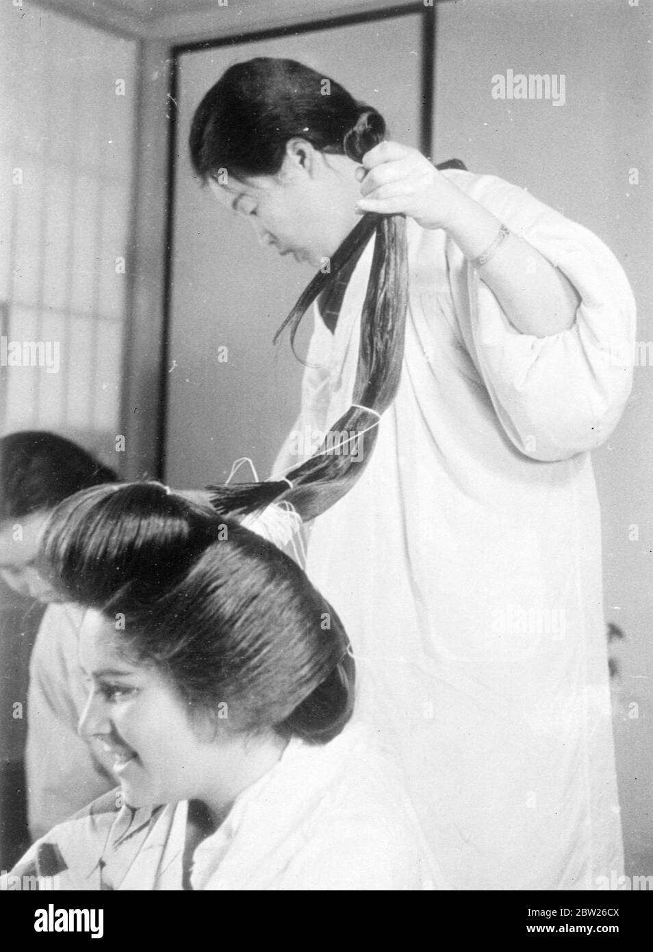 Japanische Mädchen einreichen, um 2 Stunden Agonie für verführerische coiffure. Nur wenige Menschen, die die schönen Frisuren japanischer Mädchen bewundern, erkennen die qualvolle körperliche Bestrafung, die sie durchmachen, um sie zu erhalten. Diese Bilder zeigen die komplizierten Prozesse, die nach zwei Stunden Arbeit auf Seiten des Kamiyuisan (Friseur) die endgültige Wirkung erzielen. Das Motiv für die Bilder, Adrienne Moore, und als die Frisur fertig war, sagte sie, dass sie sich beim Liegen in einem Stuhl fühlte, als ob Haskell erzählt würde und fand, dass es fast unmöglich sei, sich hinzulegen. Eine andere Tatsache, die sie entdeckte, war, dass J Stockfoto