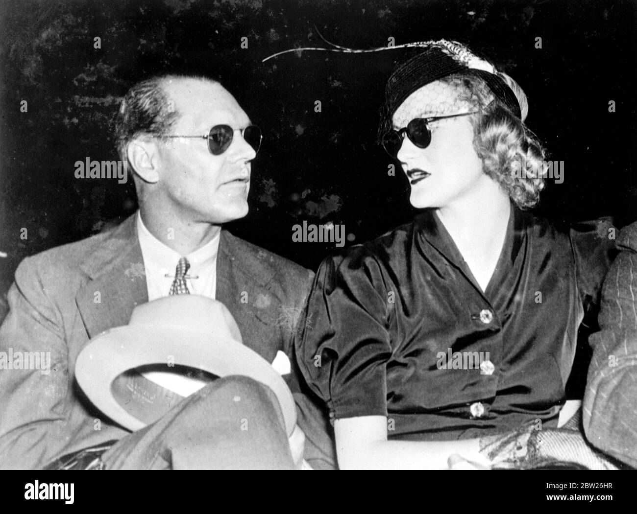 Das reichste Mädchen der Welt und ihr Mann sehen Louis, einen Sieg in einer Runde. Frau James Cromwell, die ehemalige Doris Duke, bekannt als das "reichste Mädchen der Welt", und ihr Mann James Cromwell, tragen dunkle Gläser, als sie Joe Louis seinen sensationellen Sieg über Max Schmeling im Weltmeistertitel im Yankee Stadium in New York erringen sahen. 30 Juni 1938 Stockfoto
