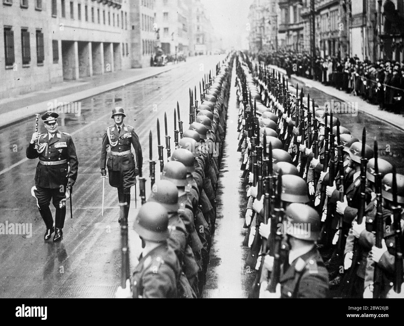 Feldmarschall Goering begrüßt die Luftstreitkräfte mit seinem neuen Baton. Feldmarschall Goering, der deutsche Luftminister, trug zum ersten Mal seinen Feldmarschall-Stab, Das ihm gerade von Hitler überreicht worden war, als er die Ehrengarde der Luftwaffe, die am "Air Force Day", dem dritten Jahrestag des offenen Auftretens vor der Welt der neuen deutschen Luftwaffe, vor dem Luftministerium in Berlin aufgestellt wurde, begutachtete. In einer Rundfunkrede bezeichnete Feldmarschall Goering die deutsche Luftwaffe als "unbesiegbar und rücksichtslos". März 1938 Stockfoto