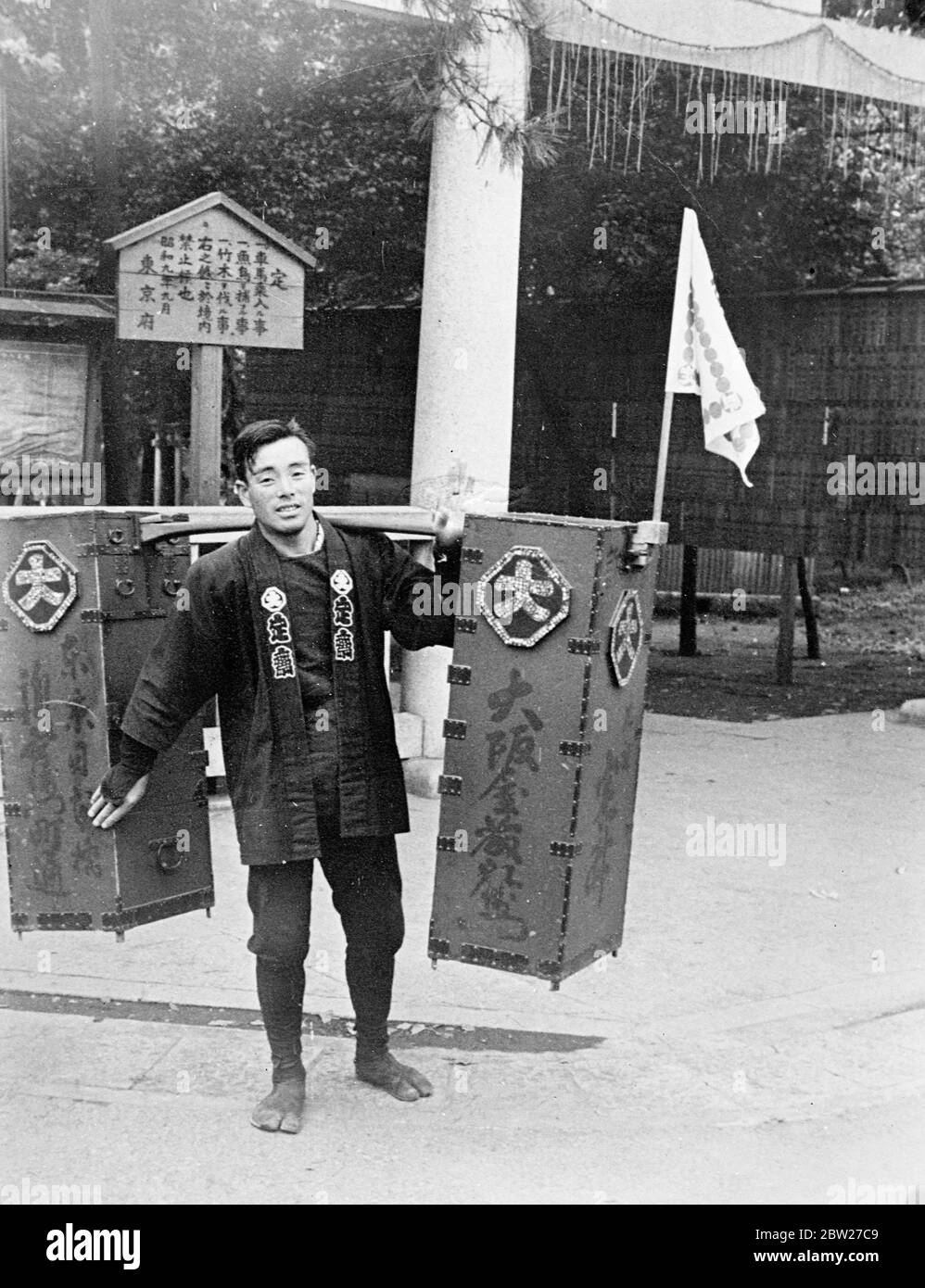 Ein japanischer Drogenhändler mit seinen dekorierten Kisten auf dem Weg von der Provinz Toyama in eine der großen Städte. Der Drogenhändler ist eine der malerischen Gestalten des alten Japan, das jetzt schnell mit dem Eingriff westlicher Ideen stirbt. Die großen Kisten, in denen er die Heilmittel für Sommerbeschwerden trägt, machten eine eigentümliche Musik, als er ging. 9 Juli 1937 [?] Stockfoto
