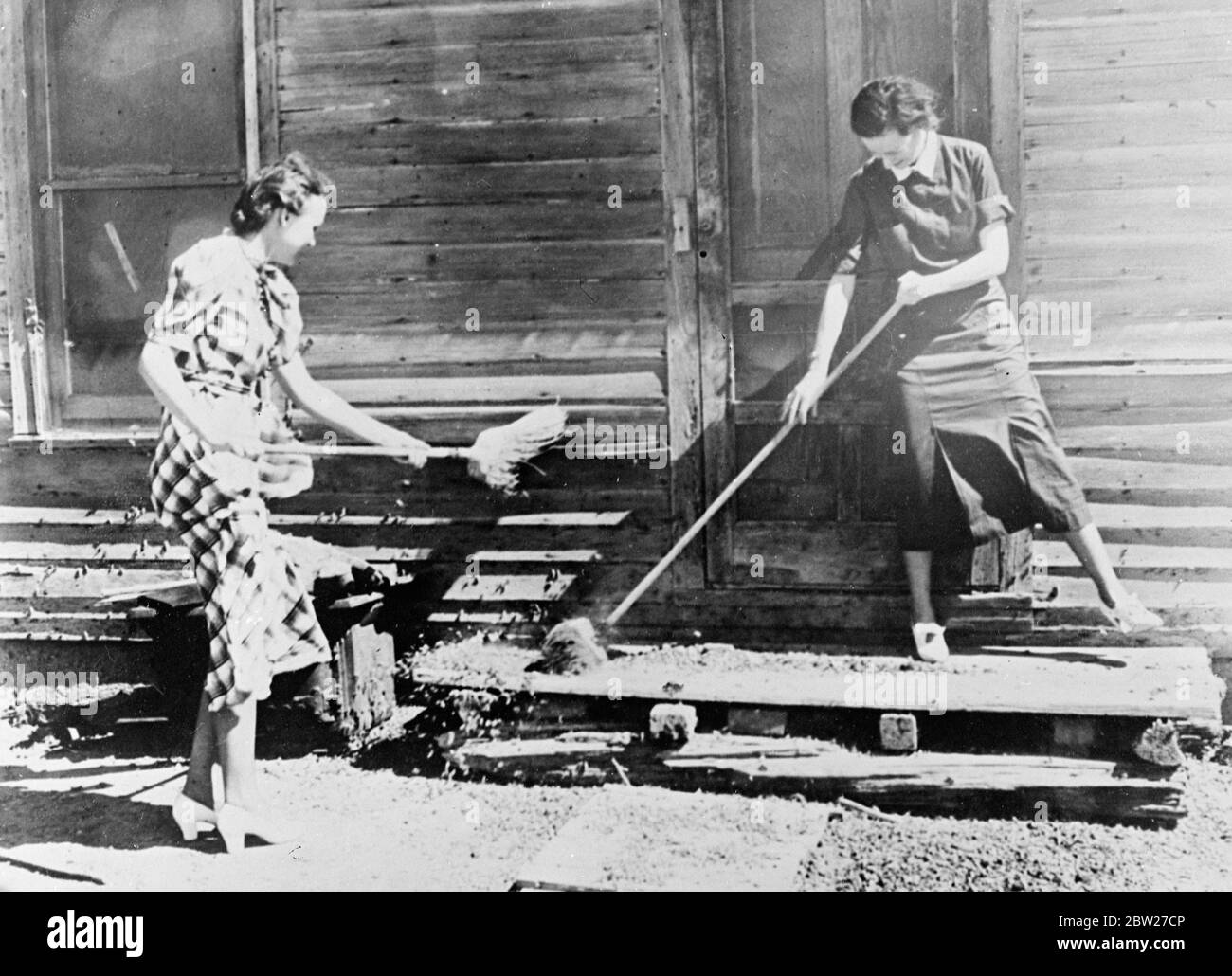 Amerika kämpft gegen eine Plage der Grasshopper. Miss Mary Deatgherage, eine Krankenschwester des Landkreises (rechts) und Miss Jane Gray, die tote und lebende Heuschrecken von der Vorderseite eines Bauernhauses in der Nähe von Colardo fegen. Juli 1937. Stockfoto