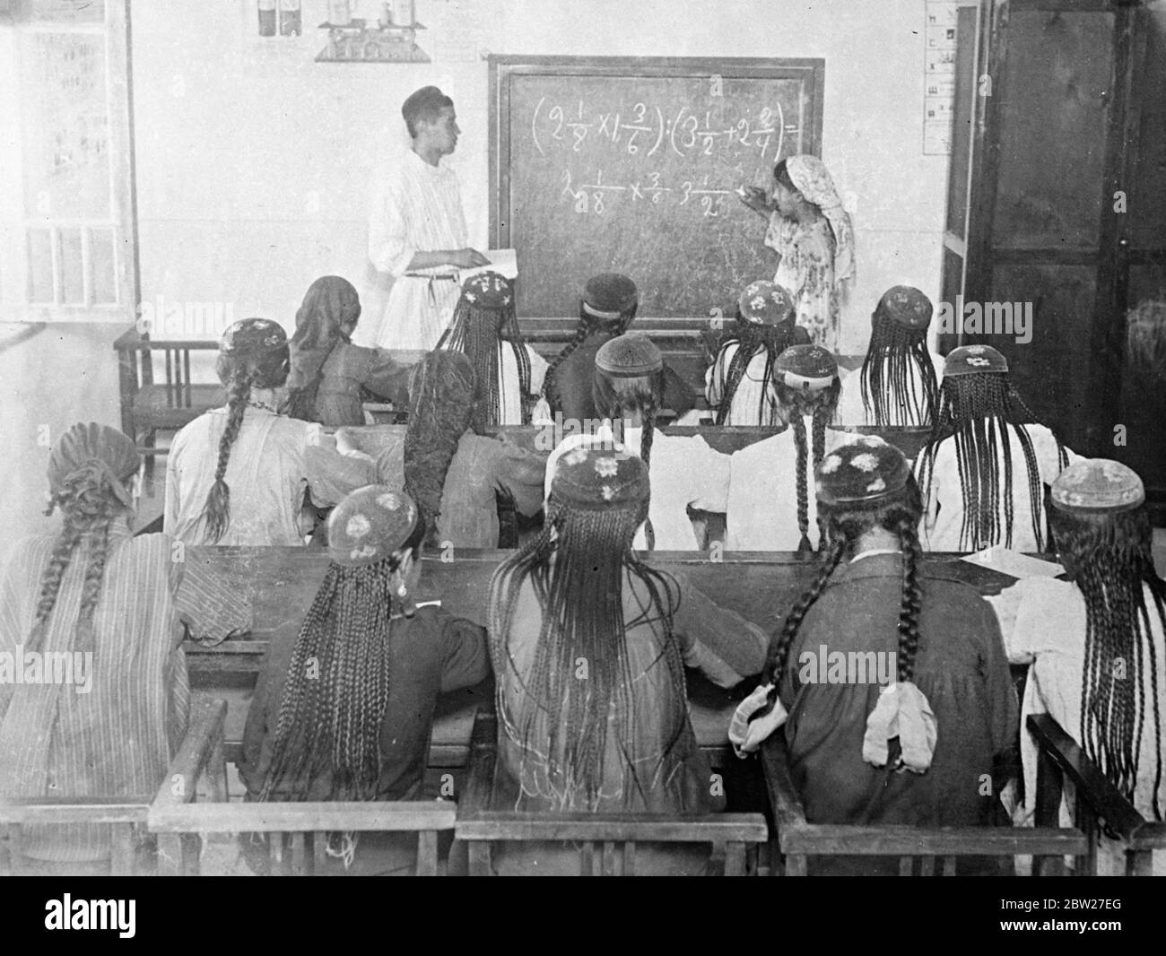 Frauen mit langen Kopfschmuck und Zöpfen in einer Klasse in Tadschikistan, Sowjetmittelasien. Im Schulzimmer sind Lehrer und Schüler mit den malerischen Kostümen ihres Landes vertraut und viele kommen direkt vom Feld, um Rechnen zu lernen. 2 Juli 1937 [?] Stockfoto