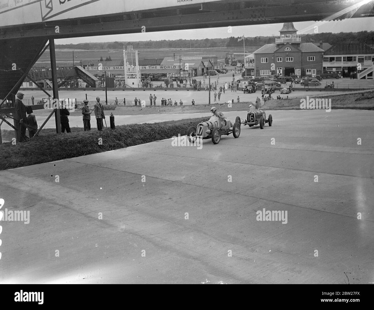 Viele der bekanntesten Rennfahrer Großbritanniens traten beim Straßenrennen-Treffen auf dem neuen Campbell Circuit in Brooklands an. Es war das erste Mal, dass Fahrerinnen an der Veranstaltung auf der neuen Strecke teilgenommen haben. No 17 und No 16 in Kurven im ersten Juli lange Handicap. 10. Juli 1937 [1. Juli 1937] Stockfoto