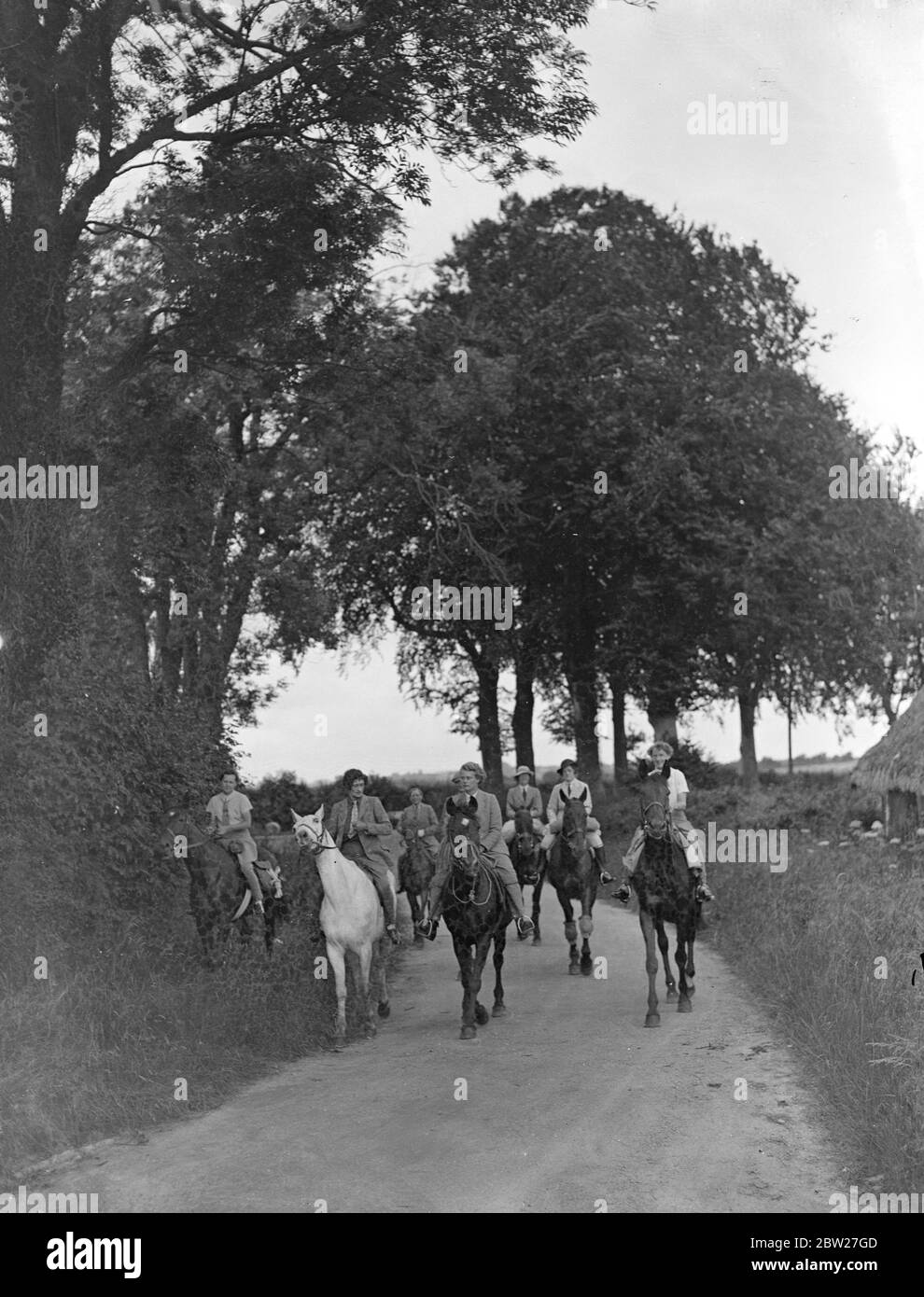 Fahrer des Garth Pony Club Teams, die durch eine baumgesäumte Landstraße auf dem Weg nach Eastbourne von Winchester. Angesichts einer 100-Meilen-Fahrt in vier Tagen verließen die Reiter Winchester heute (Sonntag), um an der ersten National Horse Rally in Eastbourne, Sussex, teilzunehmen. Hunderte von Fahrern nehmen an der Rallye Teil, die auf den Linien der Motorenbahn organisiert wird. 11 Juli 1937 Stockfoto