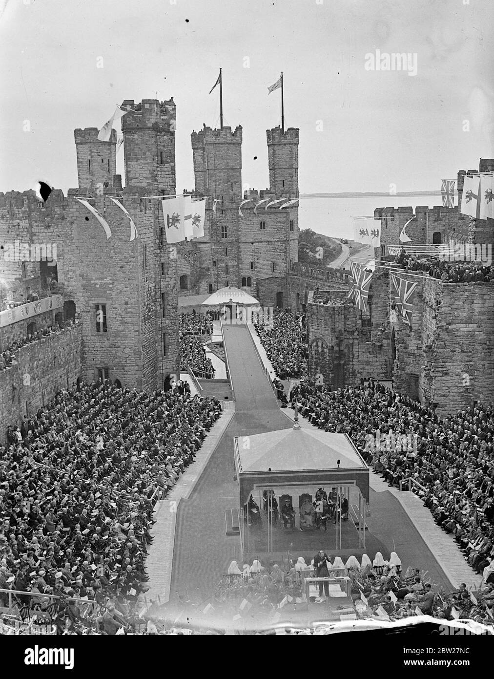 An der Stelle stehend, von der aus der Legende nach der erste Prinz von Wales den Häuptlingen gezeigt wurde, zeigten sich die König und Königin den Menschen von Wales am Ende ihrer zweitägigen Tour durch Wales im historischen Caernarvon Castle. David Lloyd George ist der Vollzugsbeamter des Schlosses. Im Hintergrund ist der Adlerturm. 15 Juli 1937. Stockfoto