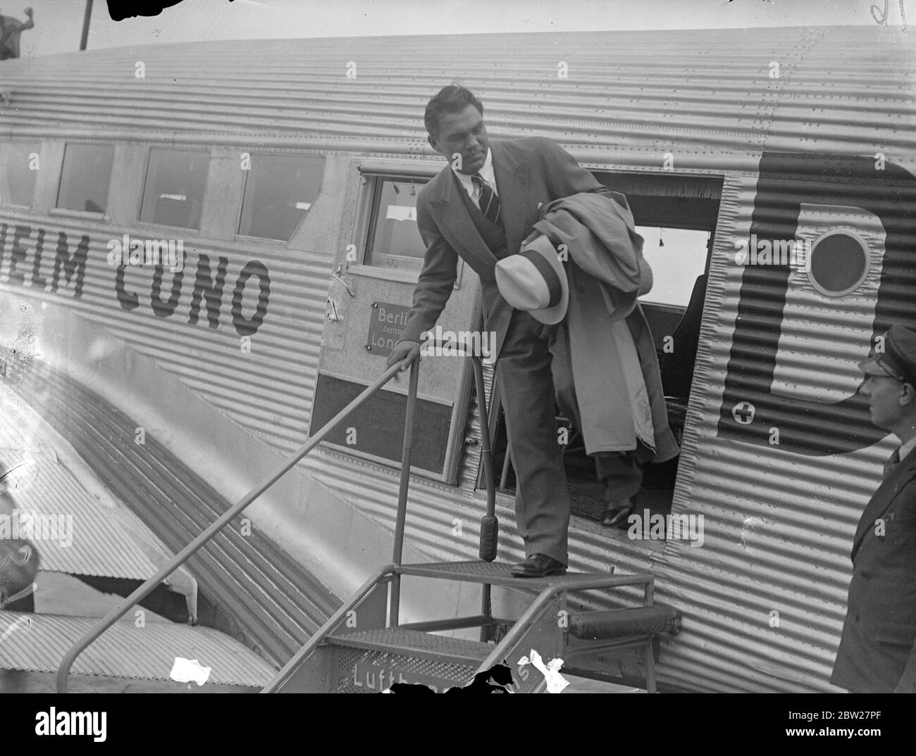 Max Schmeling, der deutsche Schwergewicht, kam von Berlin aus am Croydon Aerodrome an, um in London herauszufinden, was mit seinem Kampf gegen Tommy Farr, den britischen Empire-Champion, der angeblich im September in London stattfinden soll, passiert. Schmeling wurde von Herrn Syd Hulls begrüßt, der eine einstweilige Verfügung vorgibt, Farr vor dem Tag des Wettkampfs zwischen Schmeling und Farr vom öffentlichen Boxen abzuhalten. Juli 1937 Stockfoto