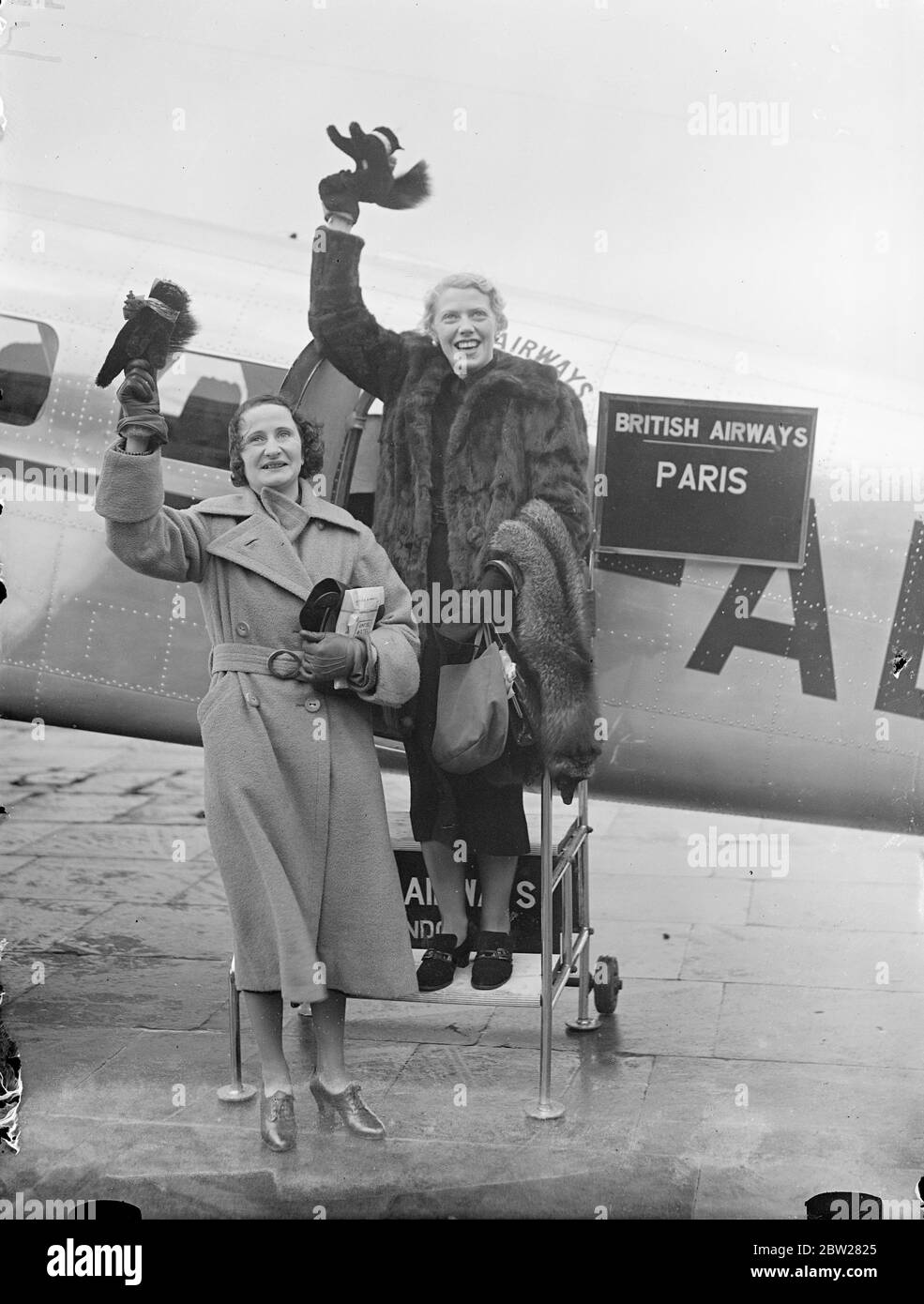 Die Fahrer fahren auf dem Luftweg, um bei der Rallye Monte Carlo anzufangen. Frau Elsie Wisdom, die Rennfahrerin, und Frau A C Lace, links, Croydon Flugplatz auf dem Weg nach Stavanger in Norwegen, von wo aus sie in der Monte Carlo Rallye, dem internationalen Winter-Motorenwettbewerb starten sollen. Mit ihnen wird Miss Amy Johnson, bei Air Pilot. Foto zeigt Frau Elsie Wisdom (links) und Frau A C Lace mit schwarzen Katzen-Maskottchen, die auf den Abschied von ihren Freunden in Croydon warten. 14. Januar 1938 Stockfoto