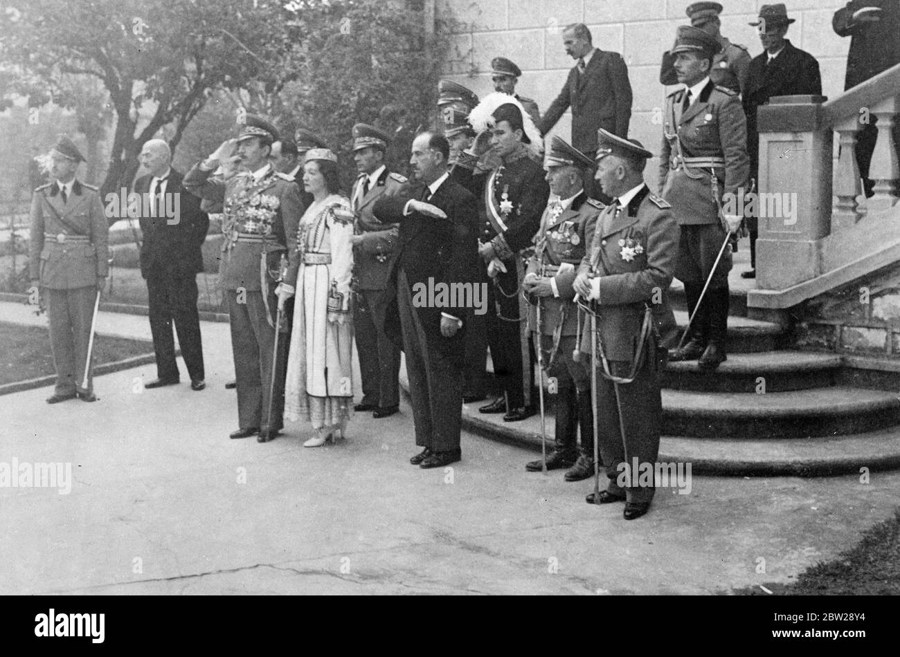 König Zog grüßen in Bauern Feier Parade in Tirana. König Zog I. nahm in Begleitung seiner Schwester, Prinzessin Senije, den Gruß an, als die albanischen Bauern während der Feierlichkeiten zum 25. Jahrestag der Unabhängigkeit der Albaner in ihren Nationaltrachten auf dem Gelände des Königspalastes in Tirana auftraten. Dezember 1937 Stockfoto