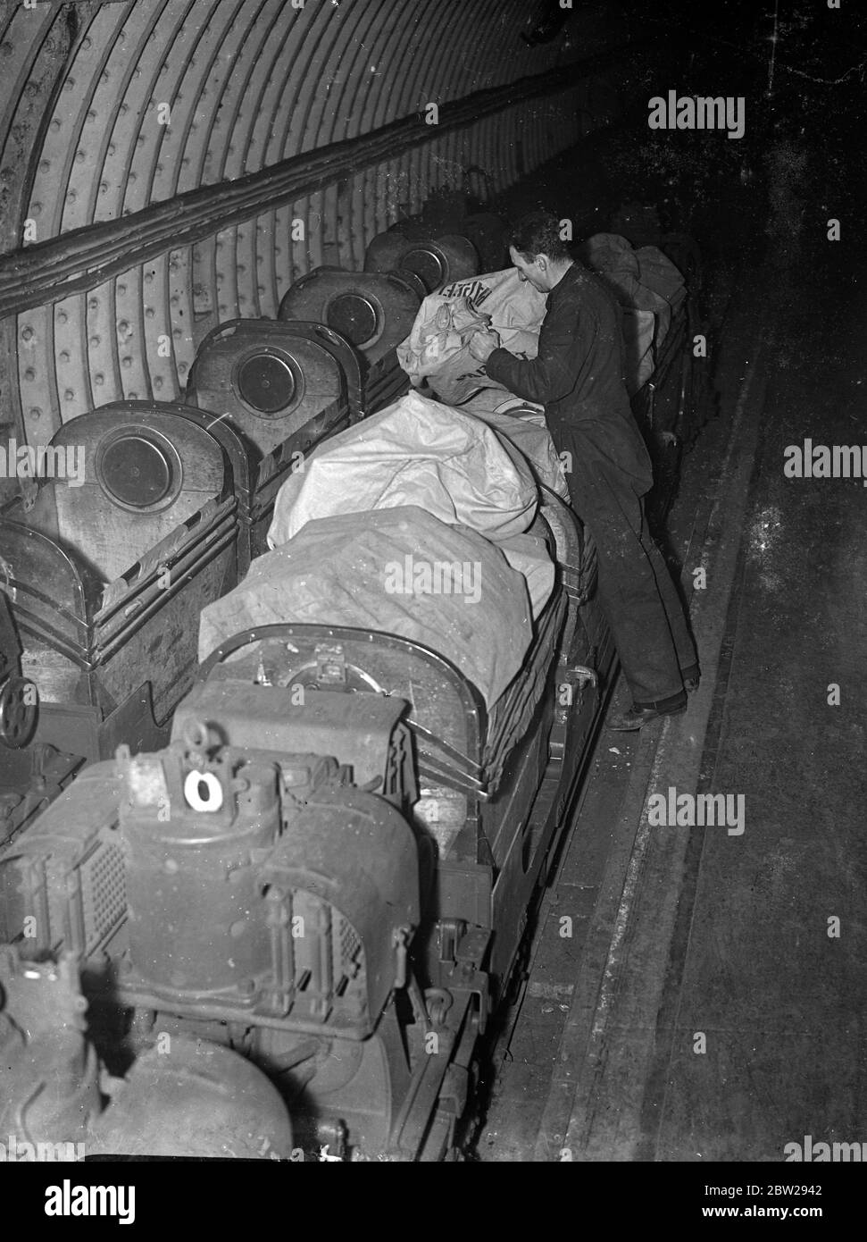 Poststellen eigene "Underground" befasst sich mit dem Weihnachtsrausch. Der übliche "Ansturm" von Paketen und Begrüßungen für die Weihnachtszeit hat seine Wirkung auf die Londoner Post Büros eigenen "U-Bahn"-Eisenbahnsystem. Die Bahn fährt vom Mount Pleasant unter London nach Whitechapel und ist jetzt bis zur Kapazitätsgrenze. Aber die Shows, Laden von Weihnachtsmails auf der Post U-Bahn, und Mount Pleasant, Clerkenwell. 21 Dezember 1937 Stockfoto