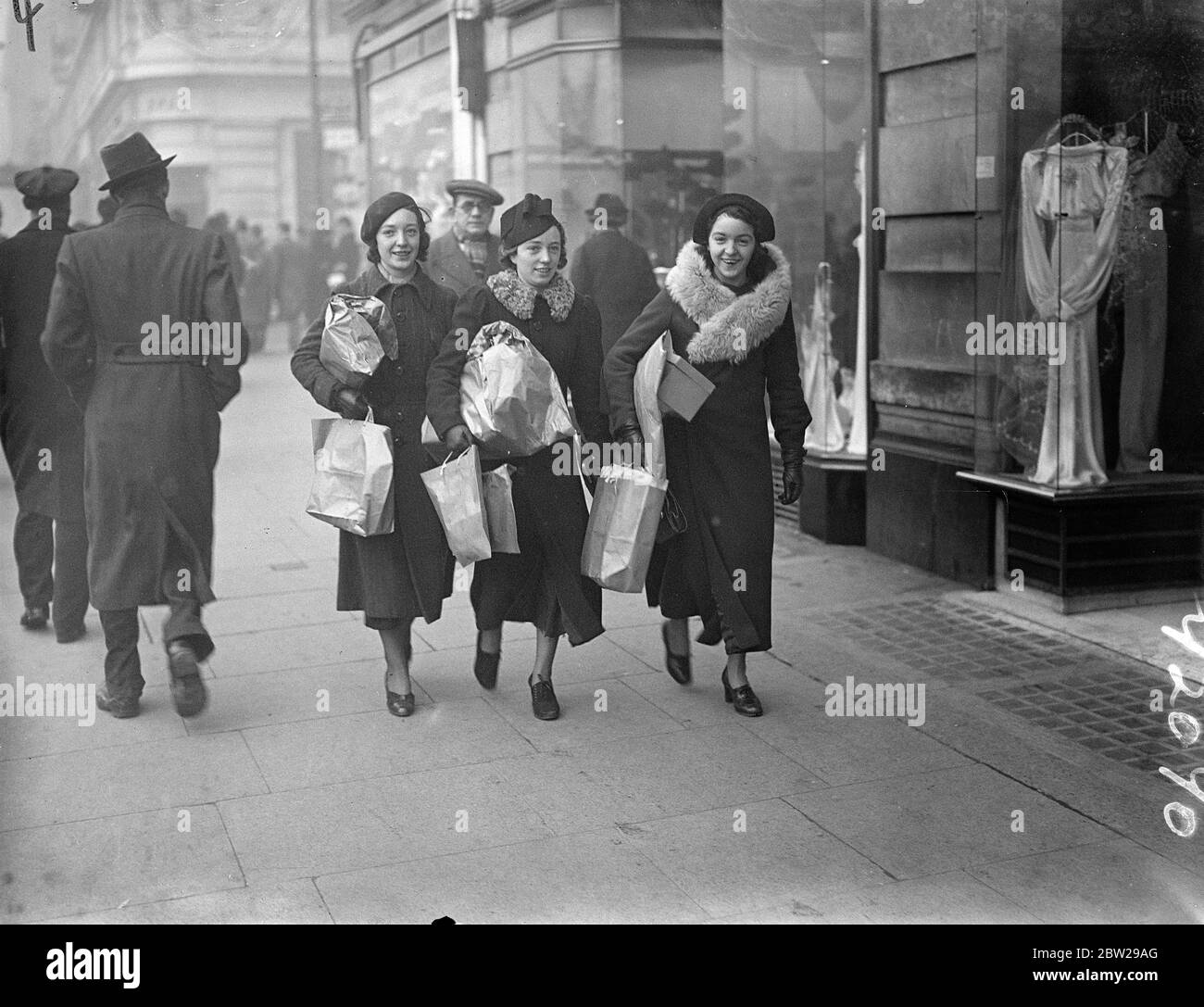 West End Shopping-Rush auf seinem Höhepunkt nur eine Woche bis Weihnachten. Mit Weihnachten, nur eine Woche entfernt, sind die Straßen des West End voll mit Shopping Massen. Foto zeigt, drei Mädchen mit Paketen in Oxford Street belastet. 18 Dezember 1937 Stockfoto