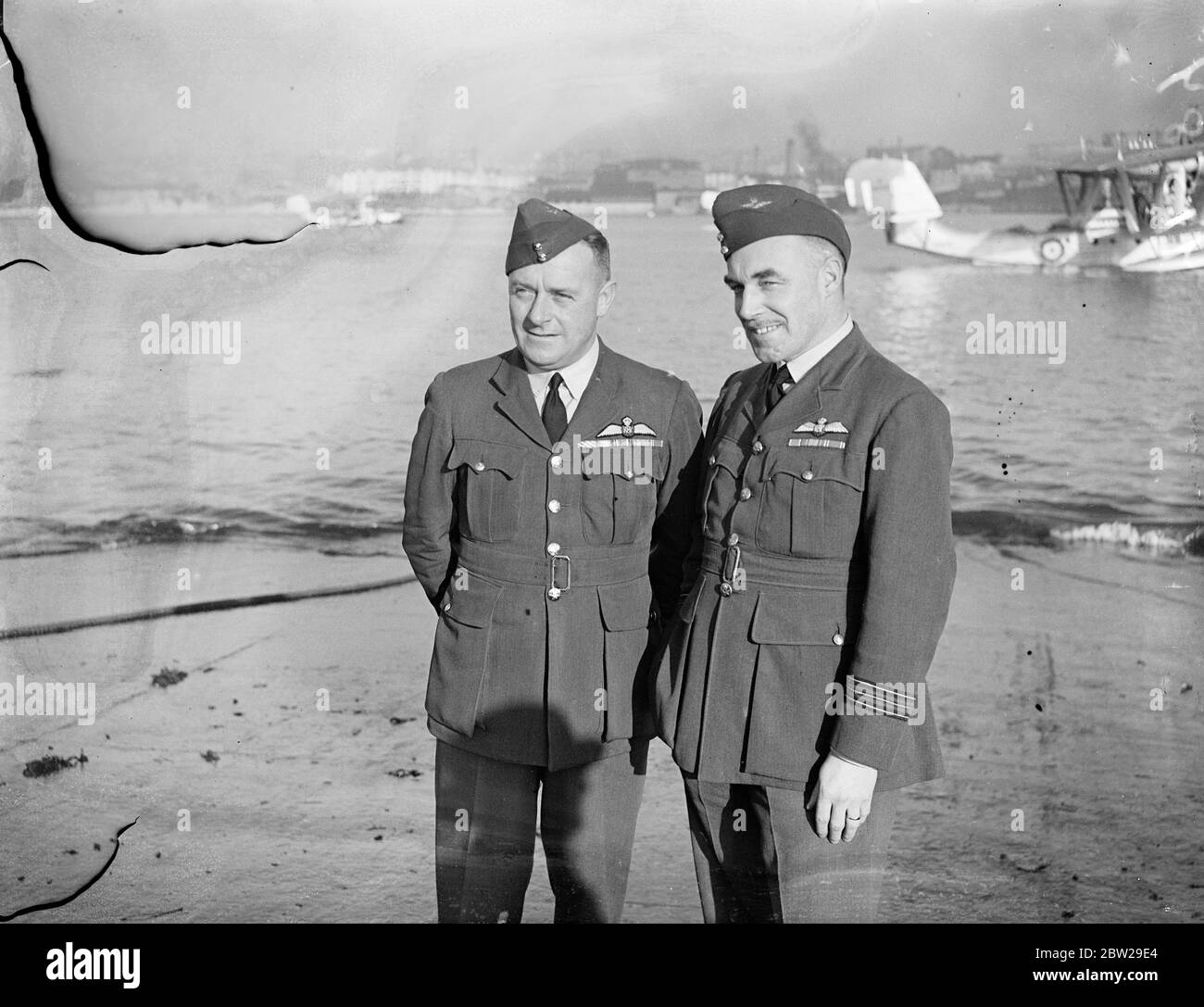 Der längste Formationsflug, den jemals von einer Service Unit unternommen wurde, sind fünf RAF-Flying Boats der Nummer 204 (Gen Reconnaissance) Squadron, die in Plymouth vorbereitet werden. Nächste Woche werden sie abheben und wenn ich im Frühjahr zurückkomme, wären sie 25,000 Meilen nach Australien und zurück geflogen. Der Besuch findet im Zusammenhang mit der 150-jährigen Feier von Sydney statt. Foto zeigt, Wing Commander Kenneth Lloyd AFC (links) , Kommandant der 204. Squadron, der die Formation mit dem Leiter der Geschwader VP Feather in Mountbatten, Plymouth, leiten wird. In der oberen rechten Ecke eine der Saunders Roe A Stockfoto