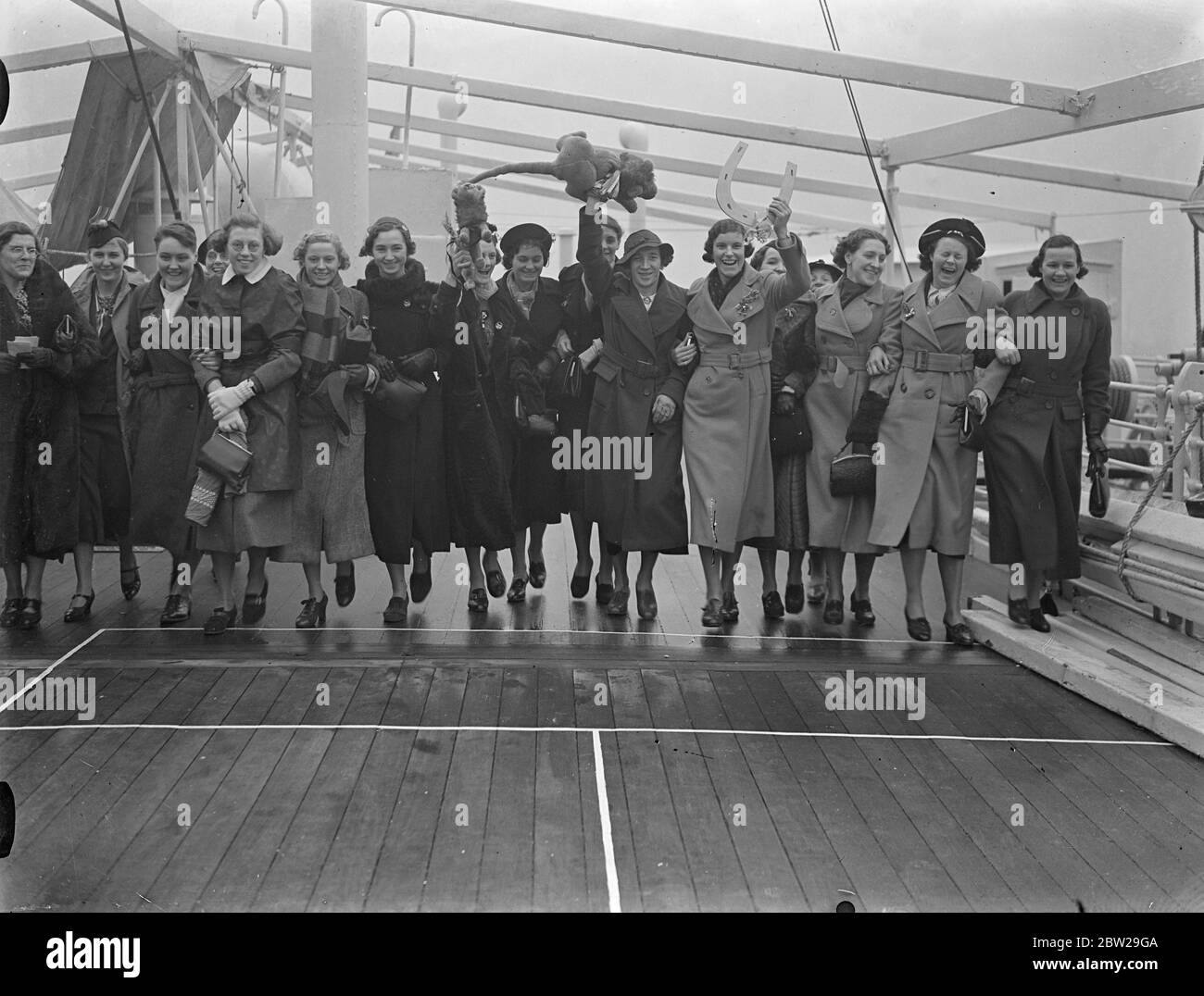 England Vertreter für Empire Games Verkauf für Australien. Athleten, die England bei den Empire-Spielen in Sydney, Australien, vertreten werden, verließen Tilbury auf dem Liner 'Ormonde'. Foto zeigt, Frauen Athleten auf dem Deck der 'Ormonde' mit ihrem Maskottchen zu Fuß, als sie Tilbury verlassen. Dezember 1937 Stockfoto