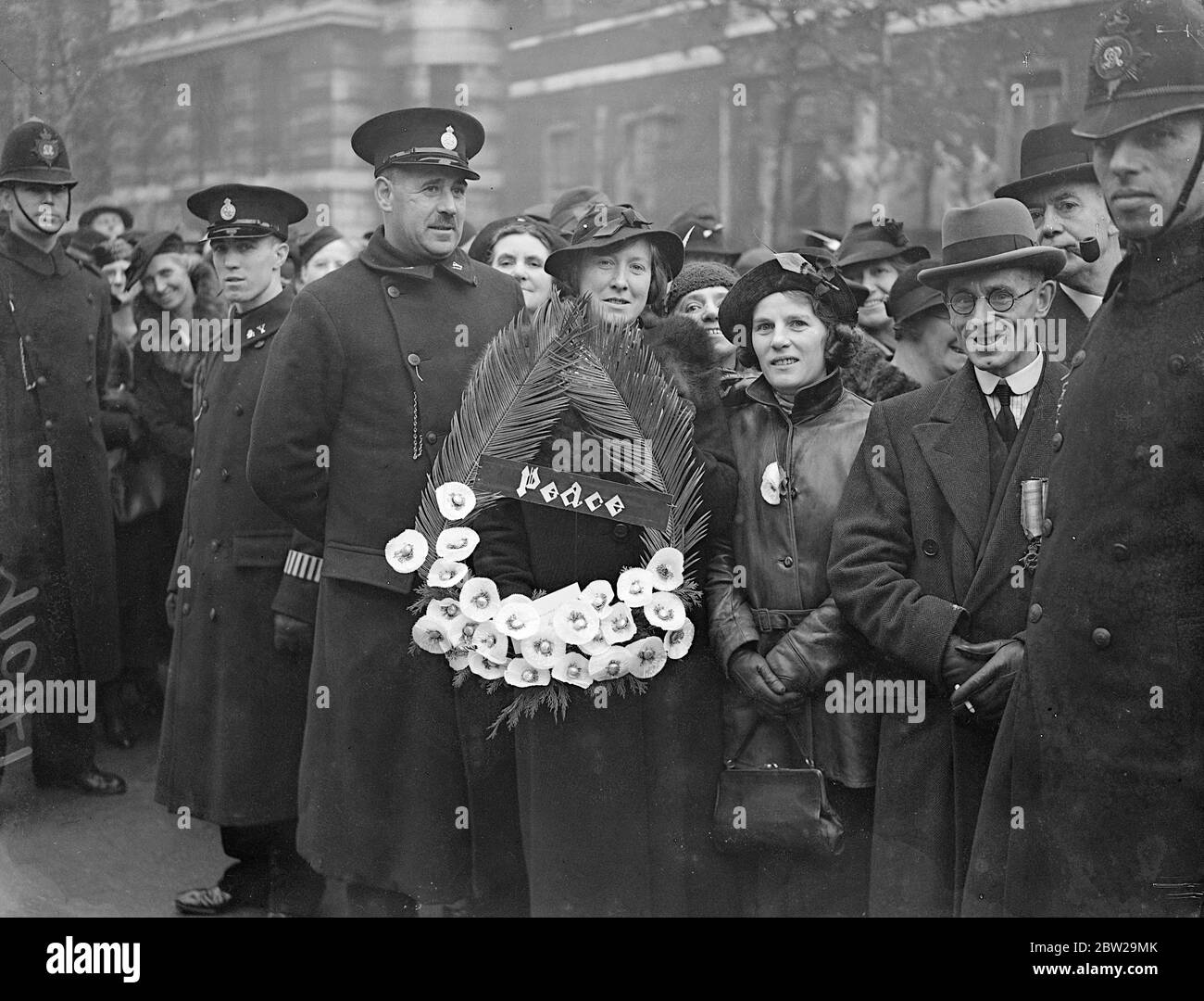 Weiße Mohnblumen für den Frieden im Cenotaph. Eine lange Schlange von Menschen stand an, um ihre Kränze auf dem Cenotaph zu legen, nach dem Waffenstillstandstag Gottesdienst. 11. November 1937 Stockfoto