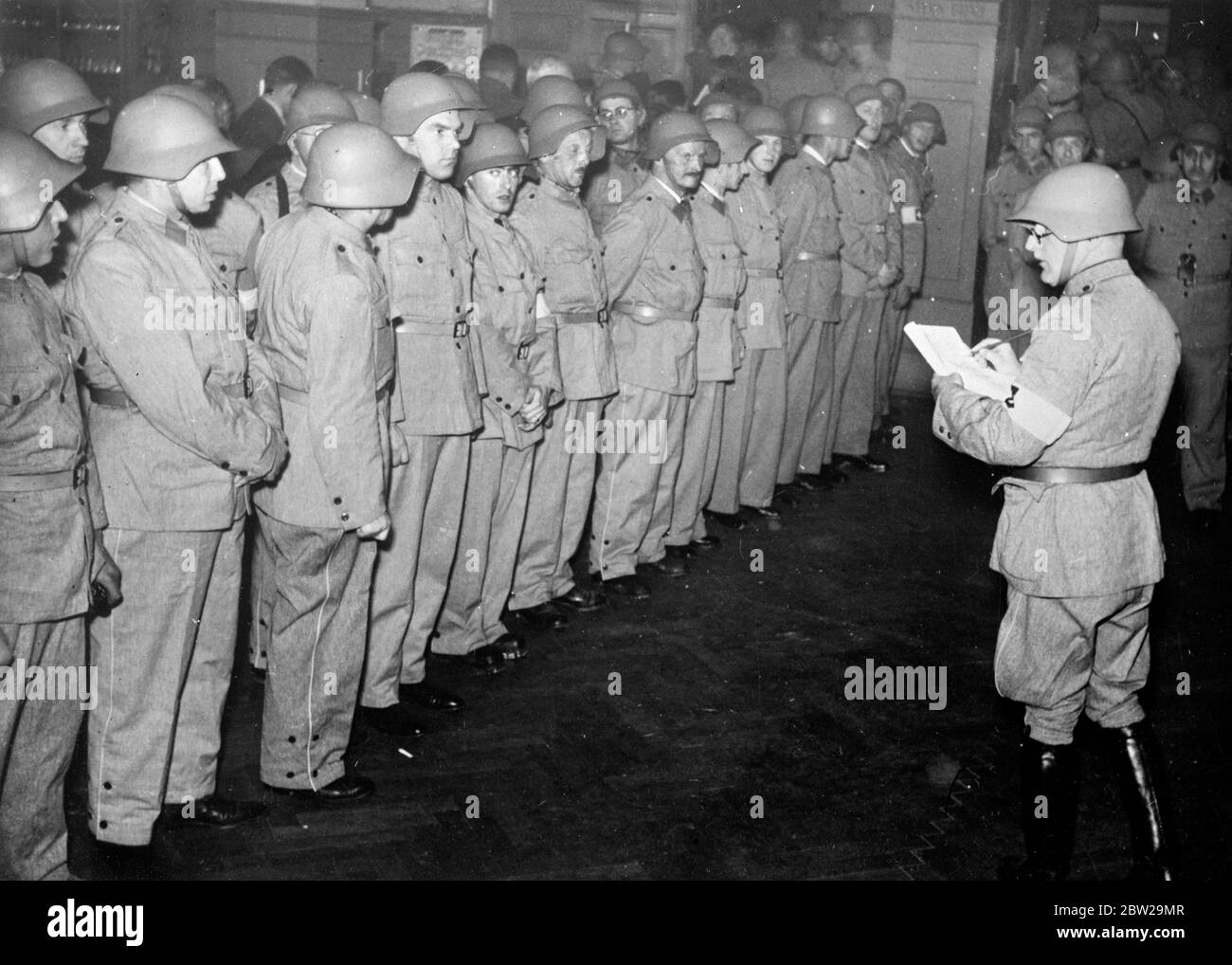 Schweizer Luftverteidigungsorganisationen testeten in Big 'Black Out'. Eine große Anzahl der Schweizer Kantone hat sich in große Anti-Luftangriffsmanöver einverleibt. Es gab einen vollständigen „Blackout“, während Verteidigungsorganisationen gründlich getestet wurden. Foto zeigt, Luftverteidigungstruppen erhalten letzte Anweisungen, bevor sie in den Dienst in verdunkelten Zürich. Allein in ZÃ¼rich waren 1600 Stahlhelmtruppen im Einsatz. 29. November 1937 Stockfoto