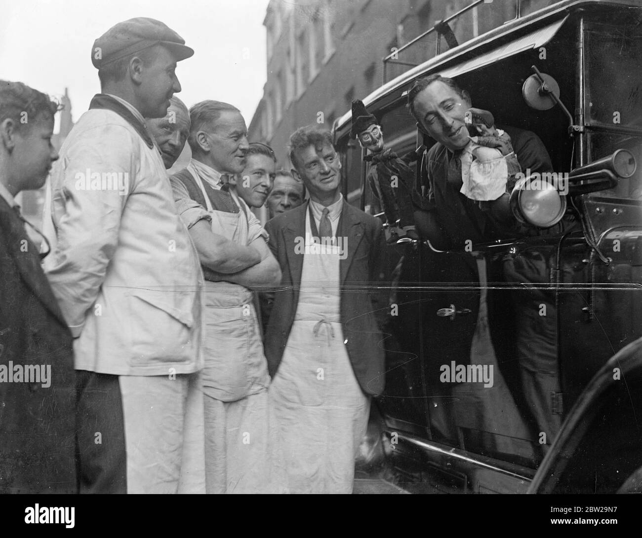 Londoner Taxifahrer als Aussteller bei der Puppentheater. Die zwölfte Ausstellung der British Puppet and Model Theatre Guild wurde im Victory House, Leicester Square, eröffnet. Die Ausstellung umfasst Puppen, Schatten, Marionetten, szenische Entwürfe und Modellbühnen. Foto zeigt Charles Tebbutt, ein Londoner Taxifahrer, der Passanten seine Punch- und Judy-Figuren zeigt, als er zur Show kam. 25. Oktober 1937 Stockfoto