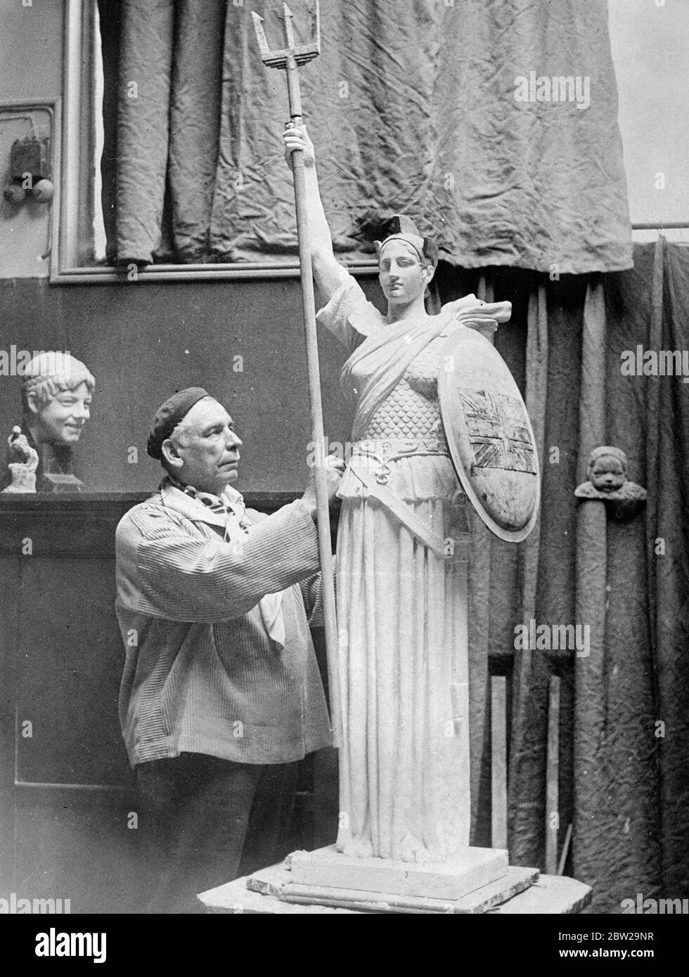 König George, um Britannia Statue in Boulogne zu eröffnen. Eine gigantische Statue von Britannia, mehr als 30 Fuß hoch und stehend auf einem hohen Sockel wird in Paris von Mons F Desruelles hergestellt und wird erwartet, dass offiziell von König George in Boulogne Sur Mer im nächsten Frühjahr eingeweiht wird. Die Statue erinnert an die Ankunft der britischen Truppen in Frankreich im Jahr 1914. Es ist in Euville Stein, der nur in Frankreich gefunden wird, und der Trident und Schild von geschlagenem Kupfer. Foto zeigt, der Bildhauer Mons F Desruelles, bei der Arbeit an einem maßstabsgegegezeichten Modell der Britannia Statue in seinem Pariser Atelier. 23. Oktober 1937 Stockfoto
