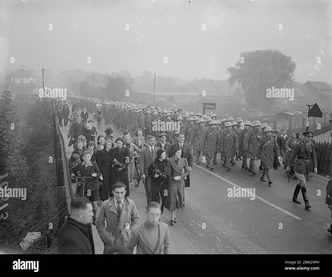 Lancers verlassen nach Indien "eskortiert" von Frauen und Kindern. Nachdem sie aus Hounslow Kasernen marschiert waren, verbargen sich die 16/5 Lancers in Feltham Station, Middlesex, nach Southampton, wo sie nach Indien einschifften. Foto zeigt, die Lancers marschieren zur Feltham Station mit Frauen und Kindern bilden eine "ethische". 14. Oktober 1937 Stockfoto
