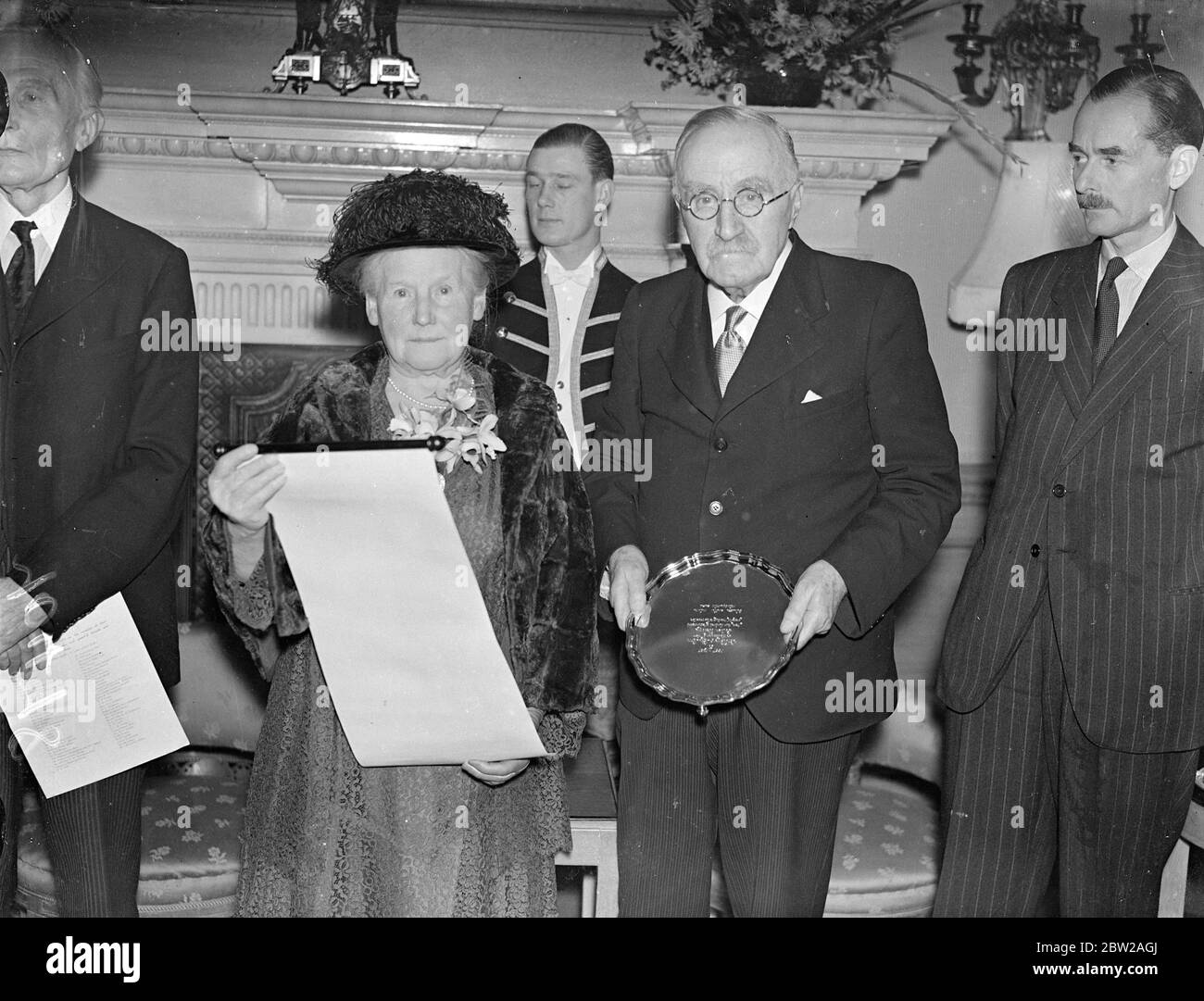 Sir Henry und Lady Lunn erhalten bei der Goldenen Hochzeit goldenen Salver. Eine Präsentation eines Goldsalvers und ein Scheck für Lady Lunn , als 500 angesehene Gäste ihren Goldenen Hochzeitsempfang im Claridges, London, besuchten. Sir Henrys Enkel, Herr Peter Lunn, war mit seiner Verlobten, der Ehrenamtwürde Antoinette Preston, anwesend. Sir Henry Lunn ist Vizepräsident der Union des Völkerbundes. Foto zeigt, Sir Henry und Lady Lunn mit dem goldenen Salver und Rollen Sie die Rezeption. 20. Oktober 1937 Stockfoto