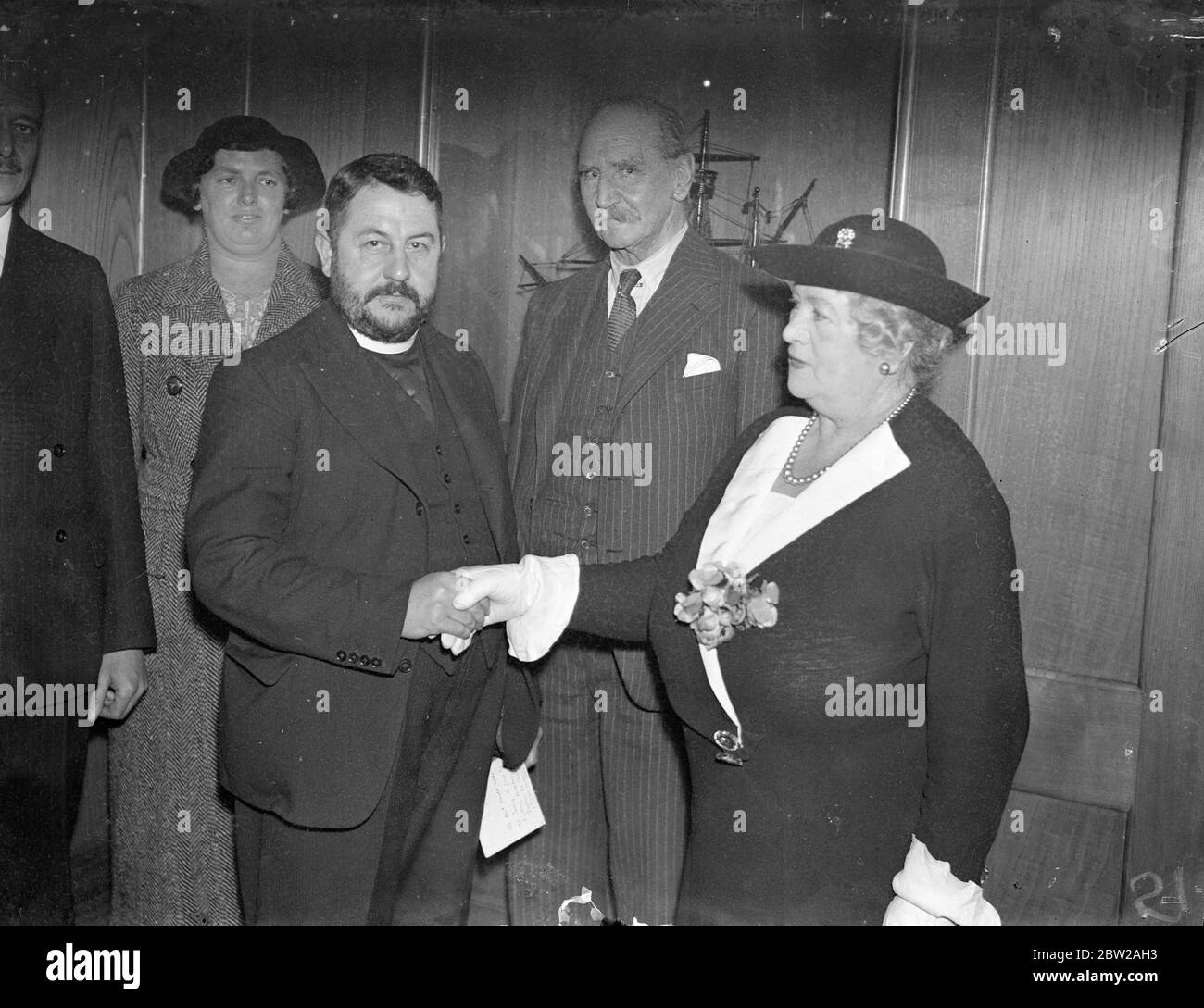 Abschiedsempfang für Chaplin von 'Worlds Loneliest Island vor seiner Rückkehr auf die einsamste Insel der Welt nahm der Pfarrer von Tristan da Cunha, Rev Harold Wilde, an einem Abschiedsempfang Teil, der von der Empire Social Group des Hauptsitzes der Royal Empire Society in der Northumberland Avenue gegeben wurde. Der am Samstag zurückkehrte Rev Wilde sagt, er sehne sich danach, nach Tristan zurückzukehren. Foto zeigt, dass der Rev Harold Wilde von Miss Margaret Baxter, Vorsitzender der Empire Social Group, und Sir Francis Morris und Vize-Vorsitzender (Mitte) 'bon voyage' gewünscht wird. November 1937 Stockfoto