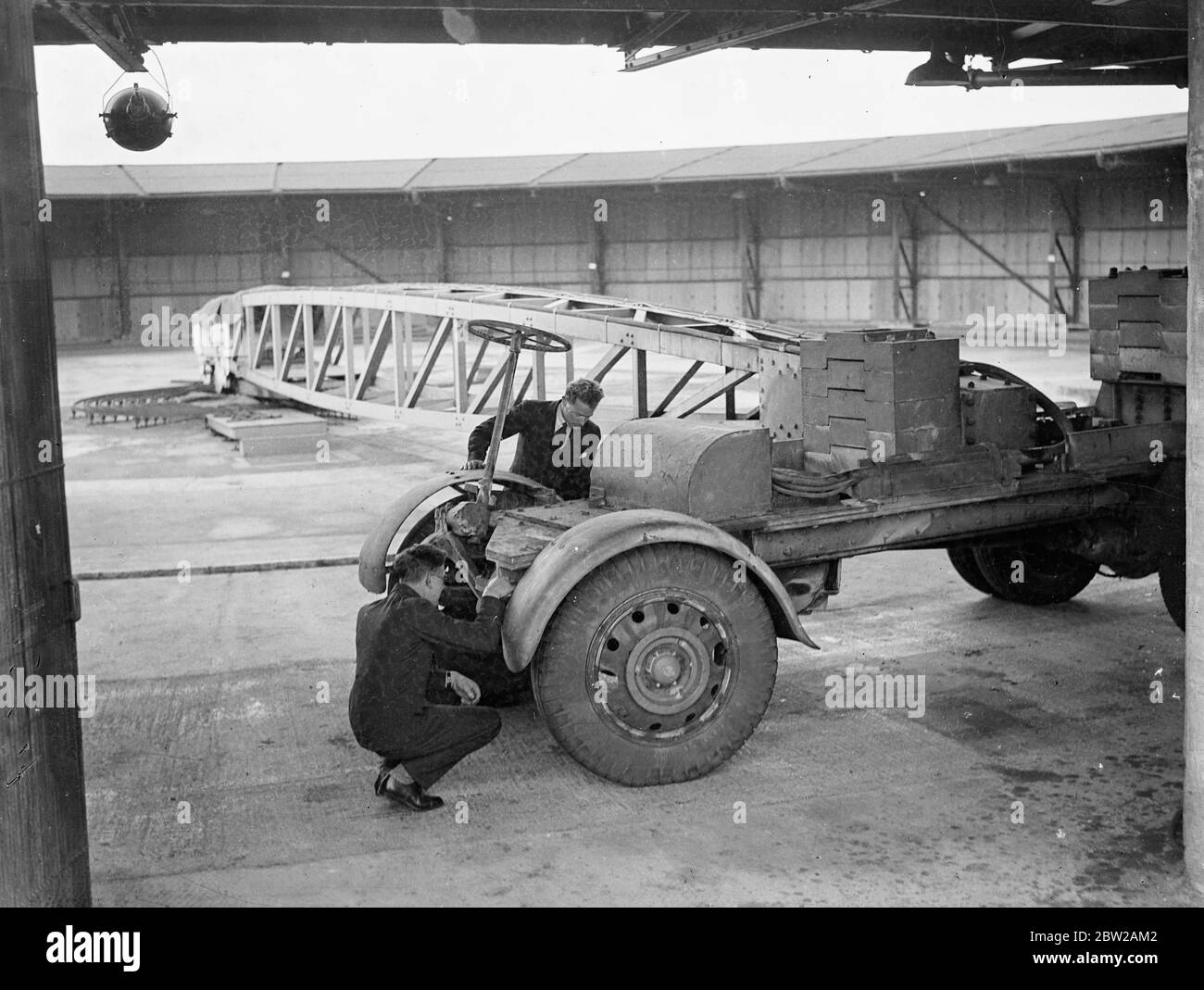 Das Verkehrsministerium testet neue Fahrbahnoberfläche mit 12 Tonnen LKW auf einem Drehpunkt. Auf der Suche nach verbesserten Straßenbelägen und übrigens auch der Straßenverkehrssicherheit verfügt das Verkehrsministerium über zahlreiche komplizierte Maschinen auf seiner Road Research Labrstory in Harmondsworth, Middlesex, nahe London, auf einer Rundbahn, die aus verschiedenen Straßenbelägen besteht. Ein schweres LKW-Fahrgestell mit einem Gewicht von 12 Tonnen eilt stündlich rund um die Uhr. Das Chassis ist durch einen schweren Träger an einem mittleren Drehteller befestigt, und macht 600 Umdrehungen der Strecke jede Stunde, so dass 15 Umdrehungen auf die Meile. Es hat bereits 70,000 Meilen zurückgelegt und hat zur Verfügung gestellt Stockfoto