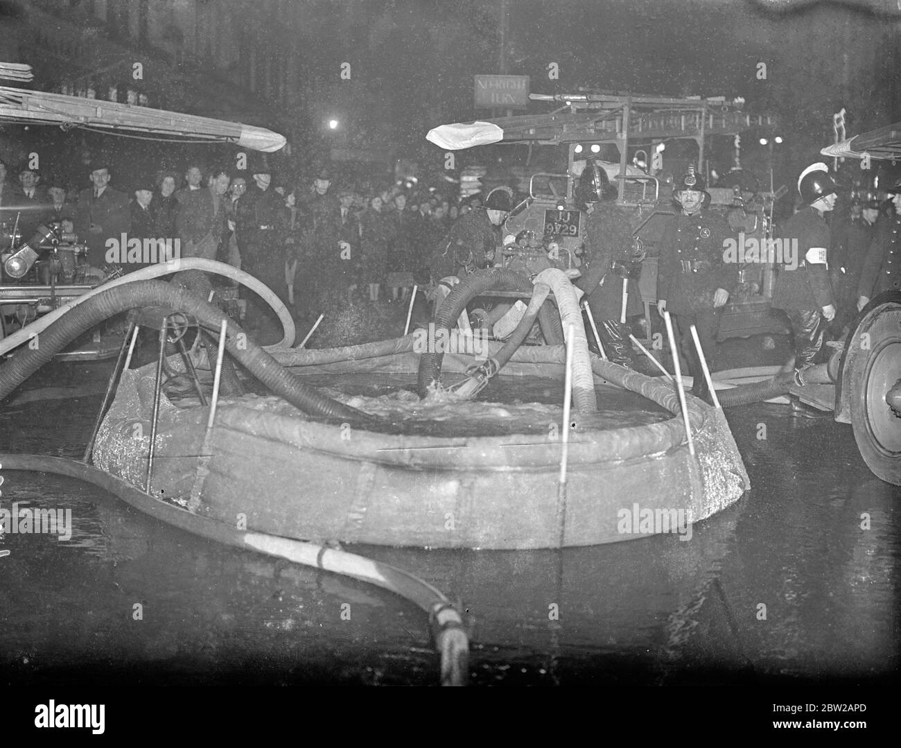 Der Anti-Luftangriffsbehälter benutzte zum ersten Mal das große Londoner Feuer. Zum ersten Mal in der Geschichte der Londoner Feuerwehr wurde ein riesiger, für den Einsatz in Luftangriffsvorsorgemaßnahmen konzipierter Canvas-Tank verwendet, um zusätzlichen Druck auf Schläuche zu gewährleisten, als ein großer Brand die Gebäude der Gramophone Company, Hersteller seines Master's Voice-Grammophons, zerstörte. Radio und elektrische Haushaltsgeräte in Oxford Street, London. Der Panzer wurde mitten in der Oxford Street, einer der verkehrsreichsten Durchgangsstraßen im West End von London, aufgestellt und der gesamte Verkehr wurde umgeleitet. 250 kämpfte Feuerwehrmann gegen die Flammen in w Stockfoto