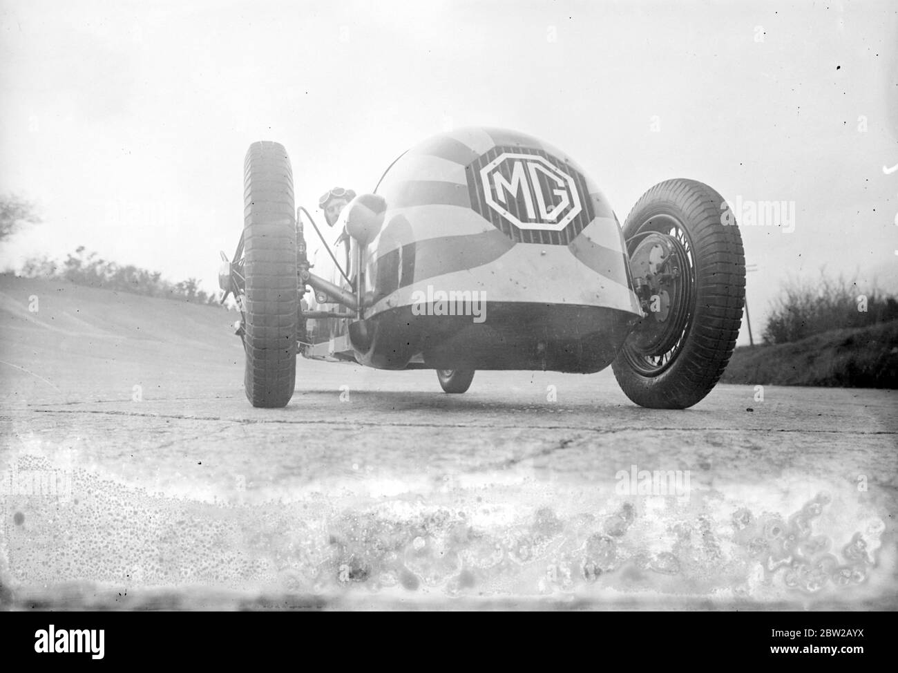 Captain George Eyston, der berühmte Rennfahrer, testete sein riesiges neues Bullet-Headed-Magnette-Auto auf der Brooklands-Rennstrecke in Weybridge, Surrey, in dem er versuchen wird, einen neuen Weltrekord für 1100 ccm-Fahrzeuge zu etablieren. Das Auto gehört zu einem Team, das dieses Jahr beim Empire Trophy Race und beim 500 Meilen Rennen in Brooklands antreten wird. Bei der Beschleunigung um die Strecke ähnelt das Auto, das braun und gelb gestreift ist, einem Kometen. [Morris Garagen, MG] 20. April 1934 Stockfoto