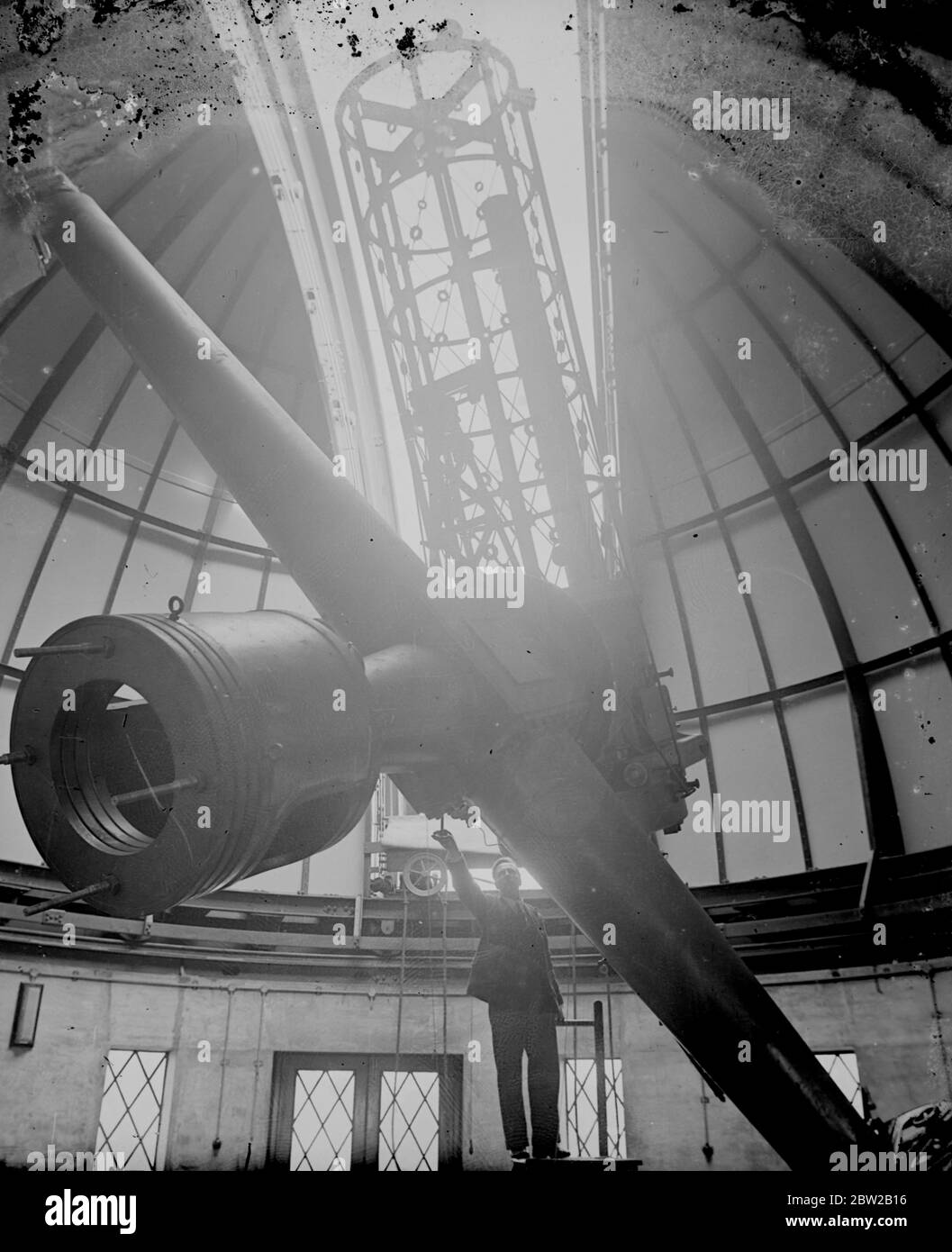 Am Greenwich Observatory in London wurde ein riesiges neues Kamerateleskop installiert, mit dem die Wärme der Sterne mittels Fotografien gemessen werden kann. Das Licht der Sterne fällt auf den Spiegel und dann mehrere Male vom Reflektor zum Reflektieren und zu einem Gefängnis, bis es schließlich die fotografische Platte erreicht. Der Spiegel des Teleskops ist 36 Zoll im Durchmesser und 6 Zoll dick und wiegt 500lb. Es dauerte zwei Jahre, um zu machen. Die Kuppel hat einen Durchmesser von 34 Fuß und der Beobachter kann alle komplizierten Instrumente mit einem Knopfdruck steuern. Der fotografische Apparat ist rechts zu sehen, während Herr E. Ma Stockfoto