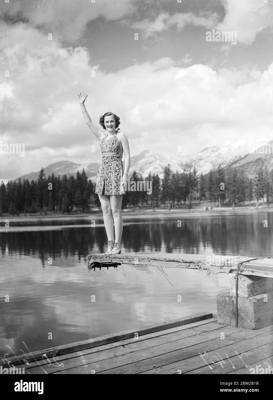 Grüße aus den kanadischen Rockies. Eine charmante Urlaubern zieht ihren riesigen Hut ab und winkt einen fröhlichen Gruß vom Mildred Lake, Jasper National Park. Pyramide und Old man Berge im Hintergrund. 20 Juni 1939 Stockfoto