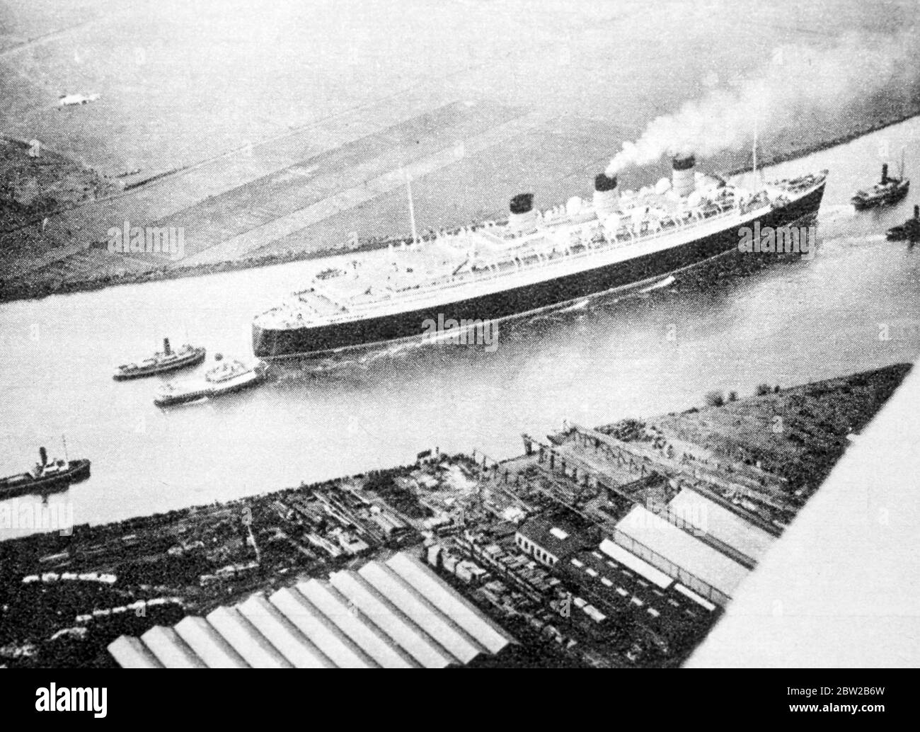 Die RMS Queen Mary wird von Schlepper gezogen. Stockfoto
