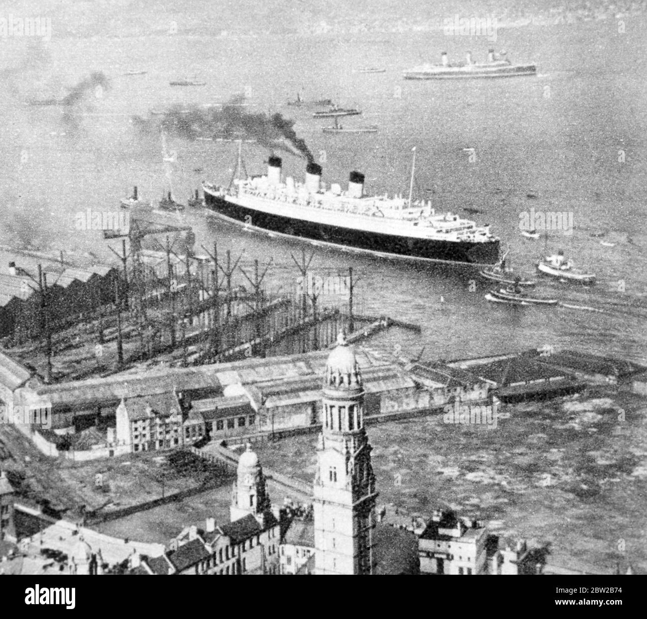 Die RMS Queen Mary wird von Schlepper gezogen. Stockfoto