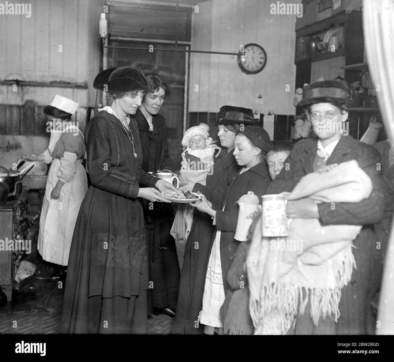 Lady Muriel Paget. Gesellschaft Damen helfen in der ungültigen Küche. Diese Küchen wurden gegründet, um den Invaliden und den Rekonvaleszenten Arbeitern täglich eine angemessene Ernährung zu bieten - jeder Empfänger muss für alle Mahlzeiten bezahlen, die berechnet werden, in einigen Fällen, die so niedrig wie ein Penny oder zwei Cent sind, entsprechend dem Lohn, der die verdiente Kapazität der bedienten Familie verdient. Lady Muriel Paget verteilt Hühnchen an einige der Bewohner, die bei den jüngsten Explosionen im East End waren. 28 Februar 1917 Stockfoto