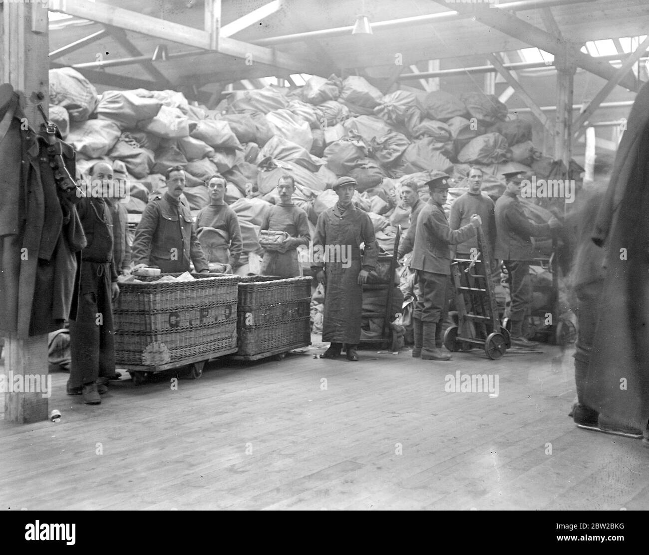 Der Umgang mit Tommy's Weihnachtspaketen im New Army Parcels Office, Regent's Park. Ein riesiger Stapel Pakete warten darauf, sortiert zu werden. 1914 Stockfoto