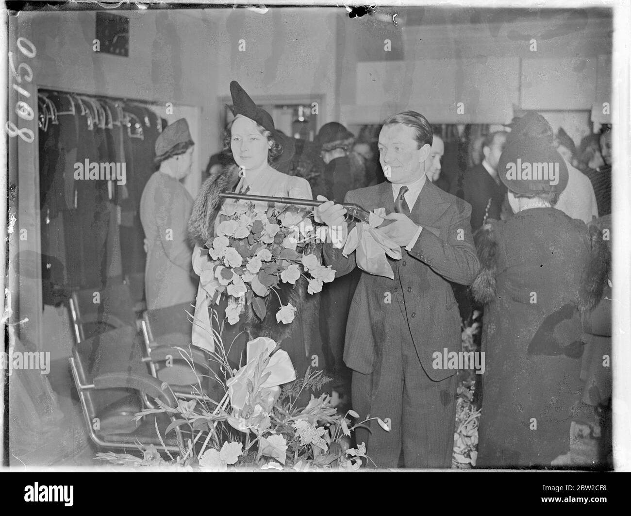 Bobby Howes, der Komiker, feuerte eine Waffe, um offiziell den neuen Goorwitch-Laden in der Oxford Street, London, zu eröffnen. Foto zeigt Bobby Howes, der die Waffe schießt. Er wird von seiner Frau begleitet. 19. Oktober 1938 Stockfoto