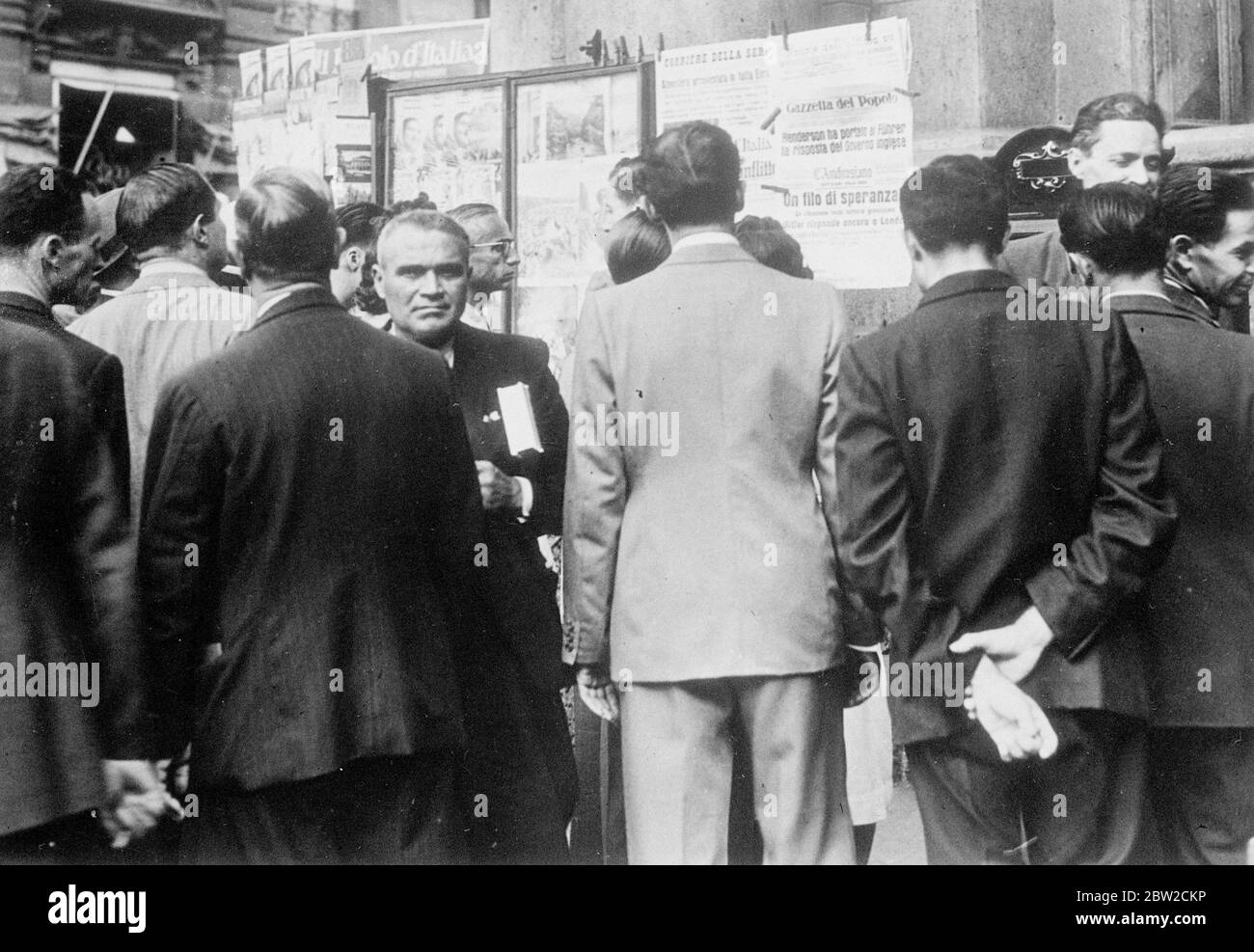 Mailänder Bürger gruppten sich um einen Zeitungsstand, um die neuesten Schlagzeilen über die internationale Krise zu lesen. Die italienische Regierung hat beschlossen, keine militärische Initiative zu ergreifen. September 1939 Stockfoto