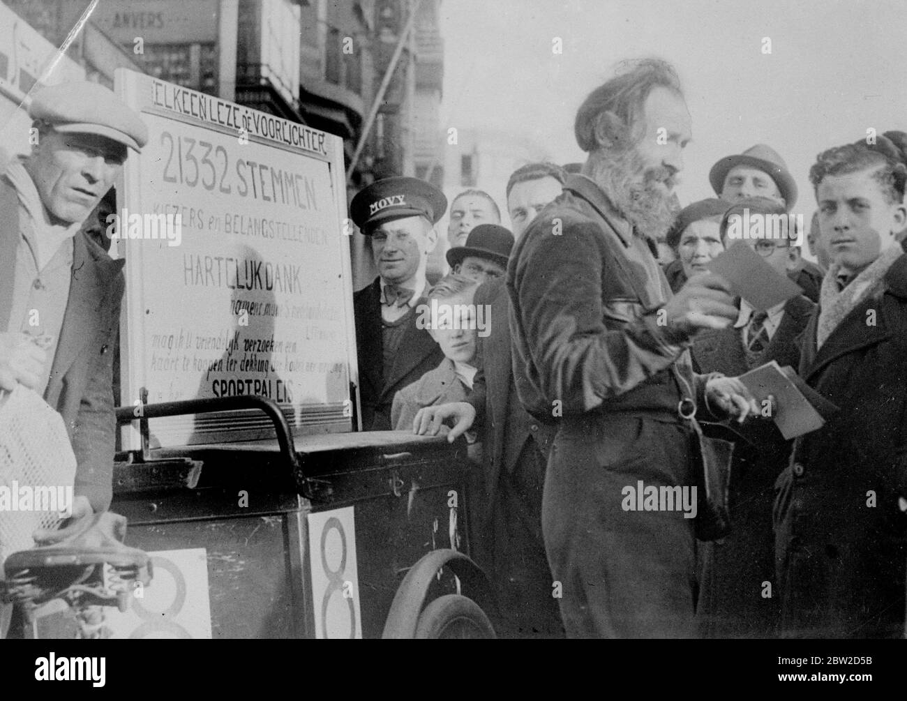 Zeigt Aufmerksamkeit auf seine Kampagne von der Straße athletische Displays, trotz der seine Jahre, ein alter Zeitungsverkäufer, M Leo Frenssen, hat einen sensationellen Sieg bei den Kommunalwahlen in Antwerpen, Belgien. M Frenssen wurde mit einer kolossalen Zahl von 21,000 Stimmen gewählt. Der bärtige Athlet zog immer eine Menge an, wenn er eine seiner Ausstellungen gibt. Foto zeigt: Leo verkauft Porträts von sich selbst in einer Antwerpener Straße. 26. Oktober 1938 Stockfoto