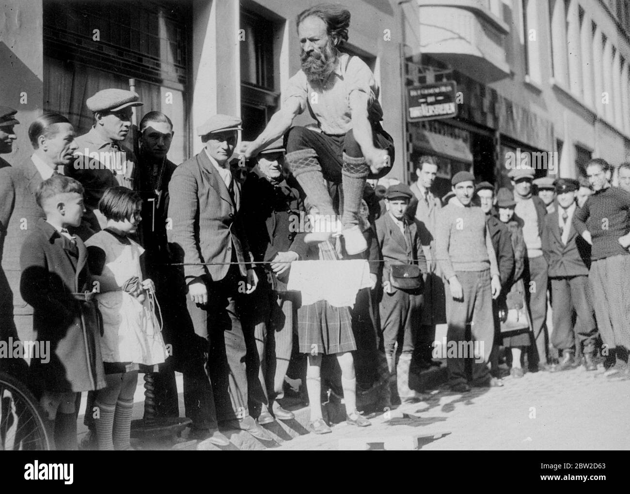 Zeichnungen Aufmerksamkeit auf seine Kampagne von Street Athletic Displays, trotz der seine Jahre, ein alter Zeitungsverkäufer, M Leo Fresno, hat einen sensationellen Sieg bei den Kommunalwahlen in Antwerpen, Belgien. M Frentzen wurde mit einer kolossalen Zahl von bis zu tausend Stimmen gewählt. Der bärtige Athlet zog immer eine Menge an, wenn er eine seiner Ausstellungen gab. Foto zeigt: Bärtiger Löwe springt weit Sie Monarchien, dass es in der Antwerp Street spielt 26 Oktober 1938 Stockfoto