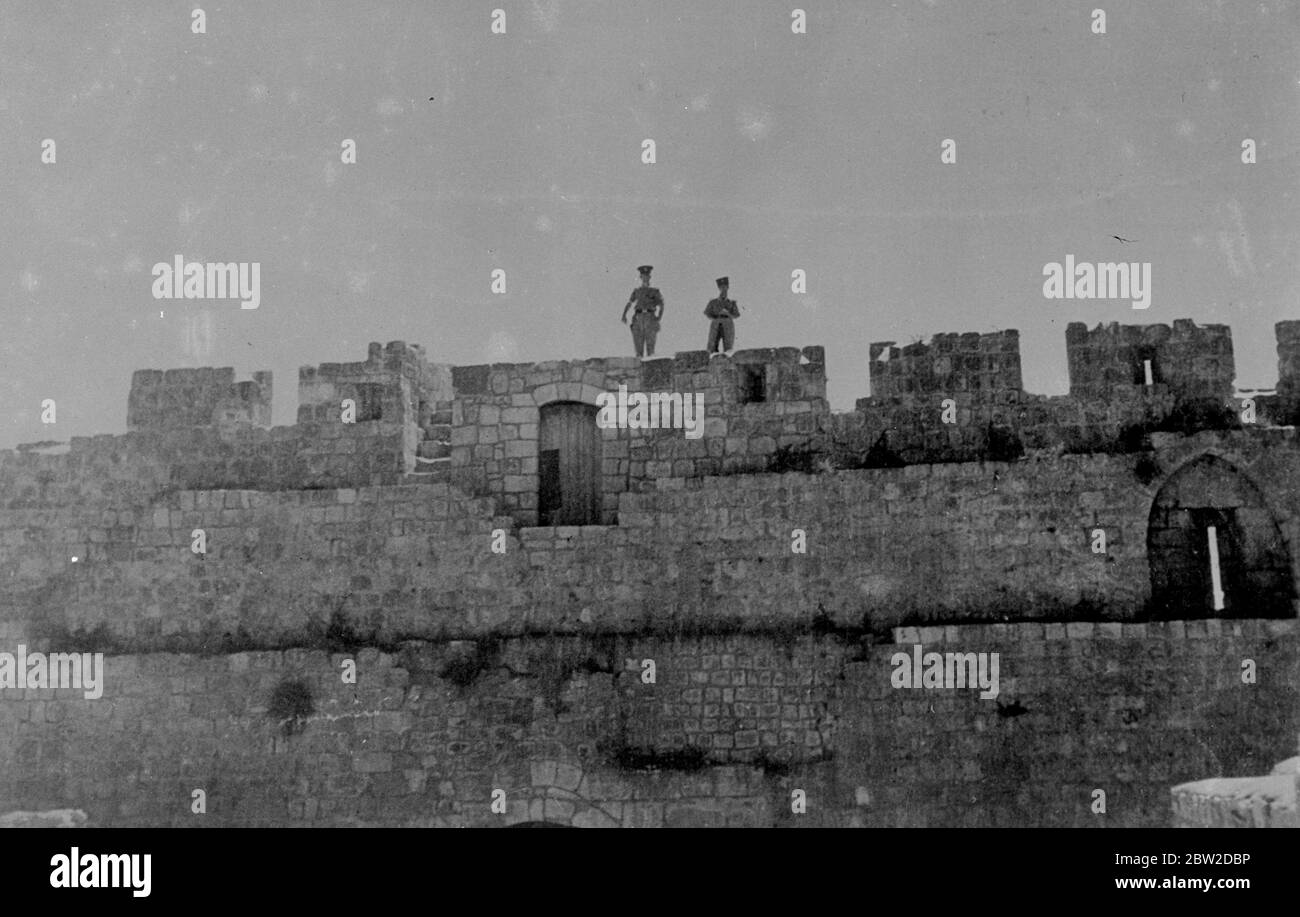 Als Ergebnis der entschlossenen militärischen Aktion der britischen Streitkräfte, die Rebellen in der Kontrolle der Altstadt von Jerusalem wurden verdrängt und britische Autorität wieder hergestellt. Der britische Angriff kam, nachdem die Araber die alte Stadt für eine Woche festgehalten hatten. 22 Araber wurden getötet und 25 verletzt. Dies war das erste Mal, dass moderne Kriegsausrüstung, einschließlich Flugzeuge, in einer Kampagne in der heiligen Stadt verwendet wurde. Fotoausstellungen: Mitglieder der palästinensischen Polizei auf Wache am Zions-Tor auf dem Berg Zion, in der alten Mauer der Altstadt, während britische Truppen mit den Rebellen umgehen 24. Oktober 1938 Stockfoto
