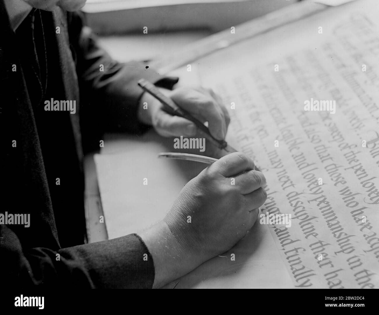 Als die Stadt London dem Premierminister Neville Chamberlain ihre Freiheit übergibt, um in Anerkennung seines Anstrebens für den Weltfrieden in München, wird die schöne beleuchtete Schriftrolle mit der schönen Handarbeit von Henry James Mainwaring aus London tragen. Herr Mainwaring wurde beauftragt, die Schriftrolle zu schreiben. Foto zeigt: Eine Nahaufnahme von Henry James Mainwarings Händen, wie er an einer beleuchteten Adresse in seinem Londoner Atelier arbeitet. Die Kunst der Illuminierung von Handschriften ist Jahrhunderte alt und wurde ausgiebig von den Mönchen praktiziert. 21. Oktober 1938 Stockfoto
