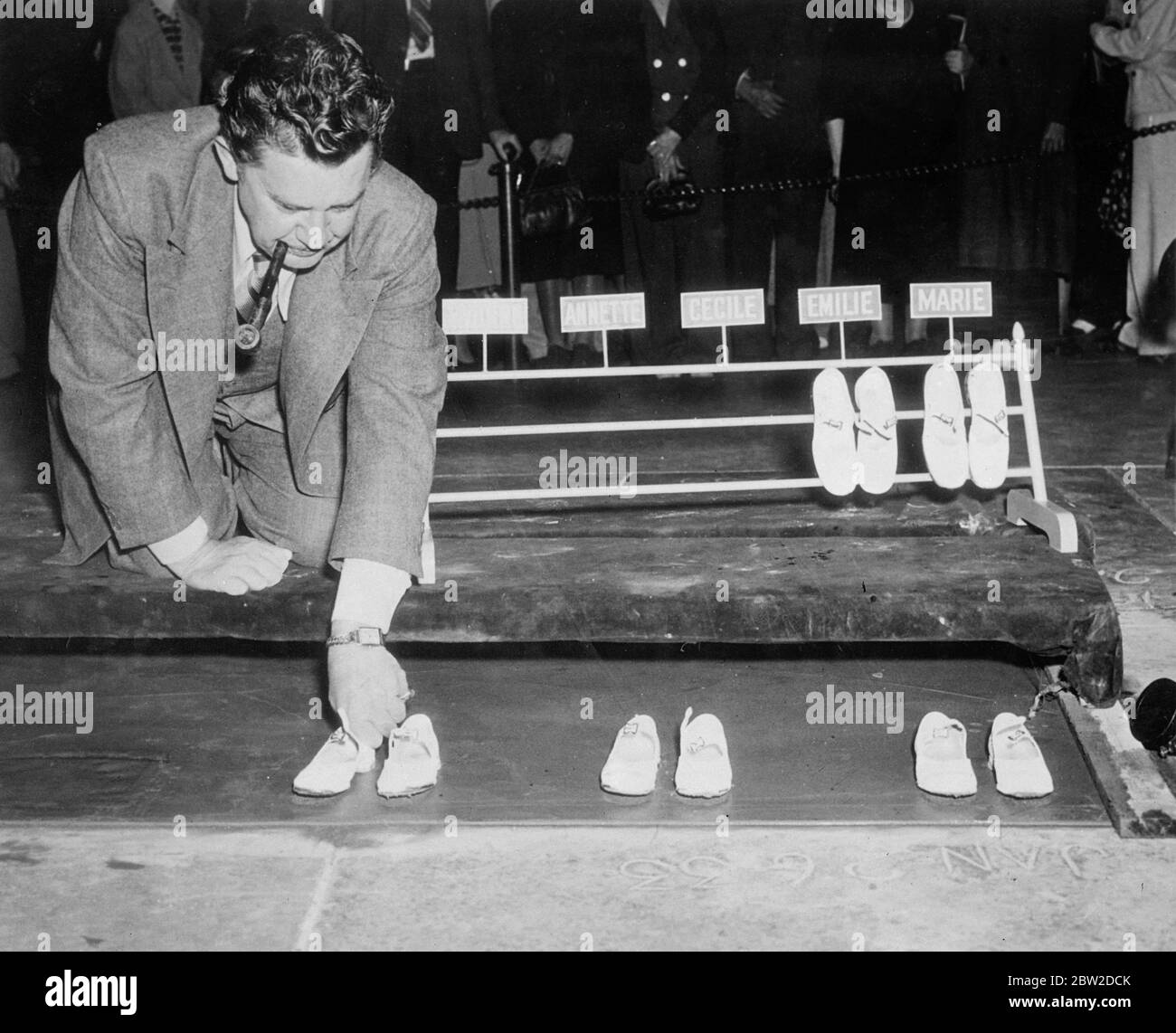 Die Fußabdruck der berühmtesten Kinder der Welt, die Dionne Quintuplets, wurden auf dem Vorplatz von Grauman's Chinese Theatre in Hollywood, durch Proxy beeindruckt. Die Zeremonie wurde von Jean Hersholt geleitet, der mit den Quins in ihren drei Filmen aufgetreten ist. Fotoausstellungen: John Hersholt macht die Quins-Fußabdrücke auf dem Vorplatz des Theaters in Hollywood. 20. Oktober 1938 Stockfoto