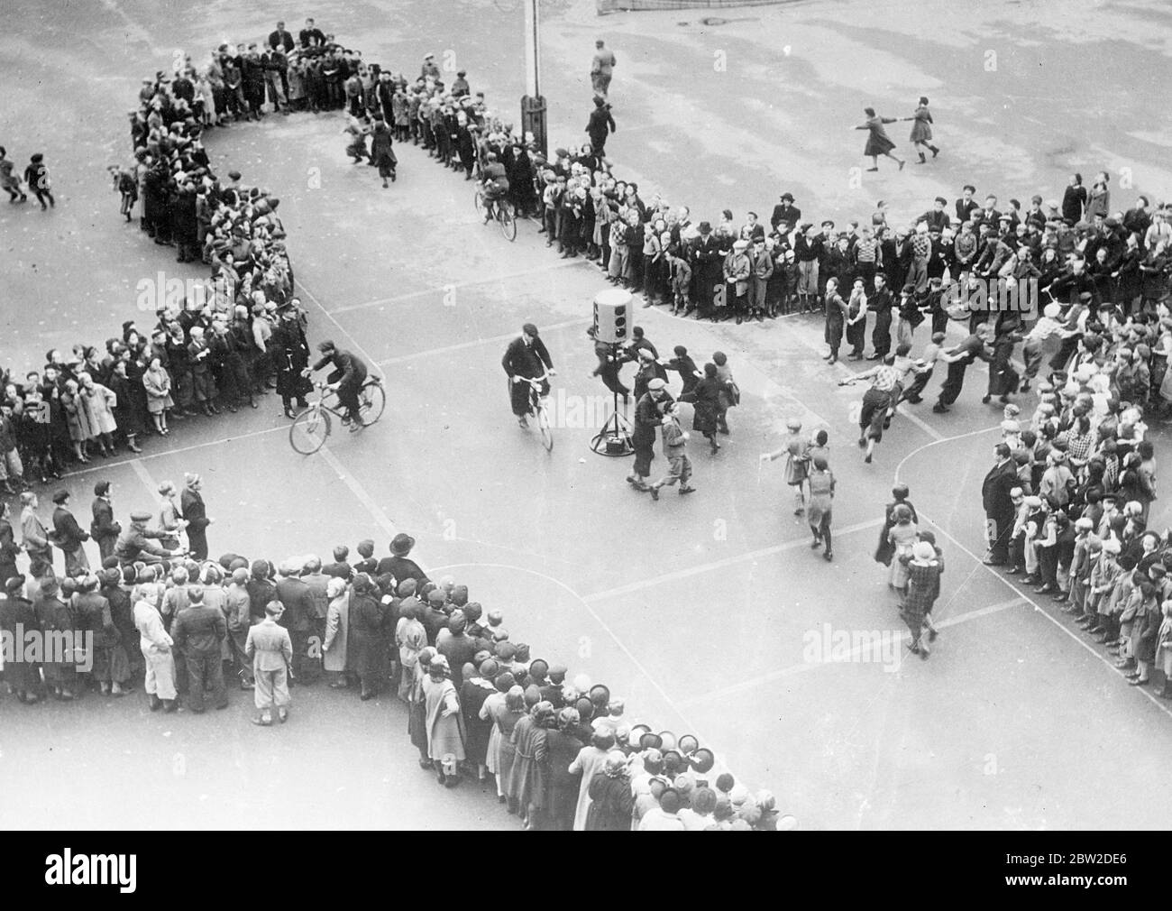Unter den Anweisungen der Polizisten werden die Schulkinder von Stockholm, Schweden, zuerst in Sicherheit unterrichtet. Auf dem Schulspielplatz werden Straßen geschalkt, kleine Ampeln installiert und die Kinder simulieren Autos und Straßenbahnen im Unterricht. Foto zeigt: Die Verkehrsstunde auf dem Spielplatz einer Stockholmer Schule unter der Leitung eines Polizisten. 16. Oktober 1938 Stockfoto