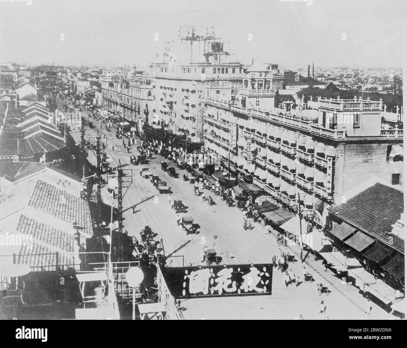 Japaner starten großen Luftangriff auf Hangkow, Bevölkerung taucht in Sicherheit. Die gesamte Bevölkerung von Hankow, dem neuen Sitz der chinesischen Regierung, tauchte in unterirdische Schutzräume, als 40 japanische Flugzeuge den Flugplatz bombardierten und ihn zu einem Trümmern verwandelten. Lewis-Geschützmannschaften an Bord der im Fluss verankerten britischen Kanonenboote standen bereit, falls sie beschossen werden sollten. 75 Bomben fielen auf den Flugplatz. Foto zeigt die Shungahan Gedenkstraße, eine der wichtigsten Geschäftsstraßen Hankows. Januar 1938 Stockfoto