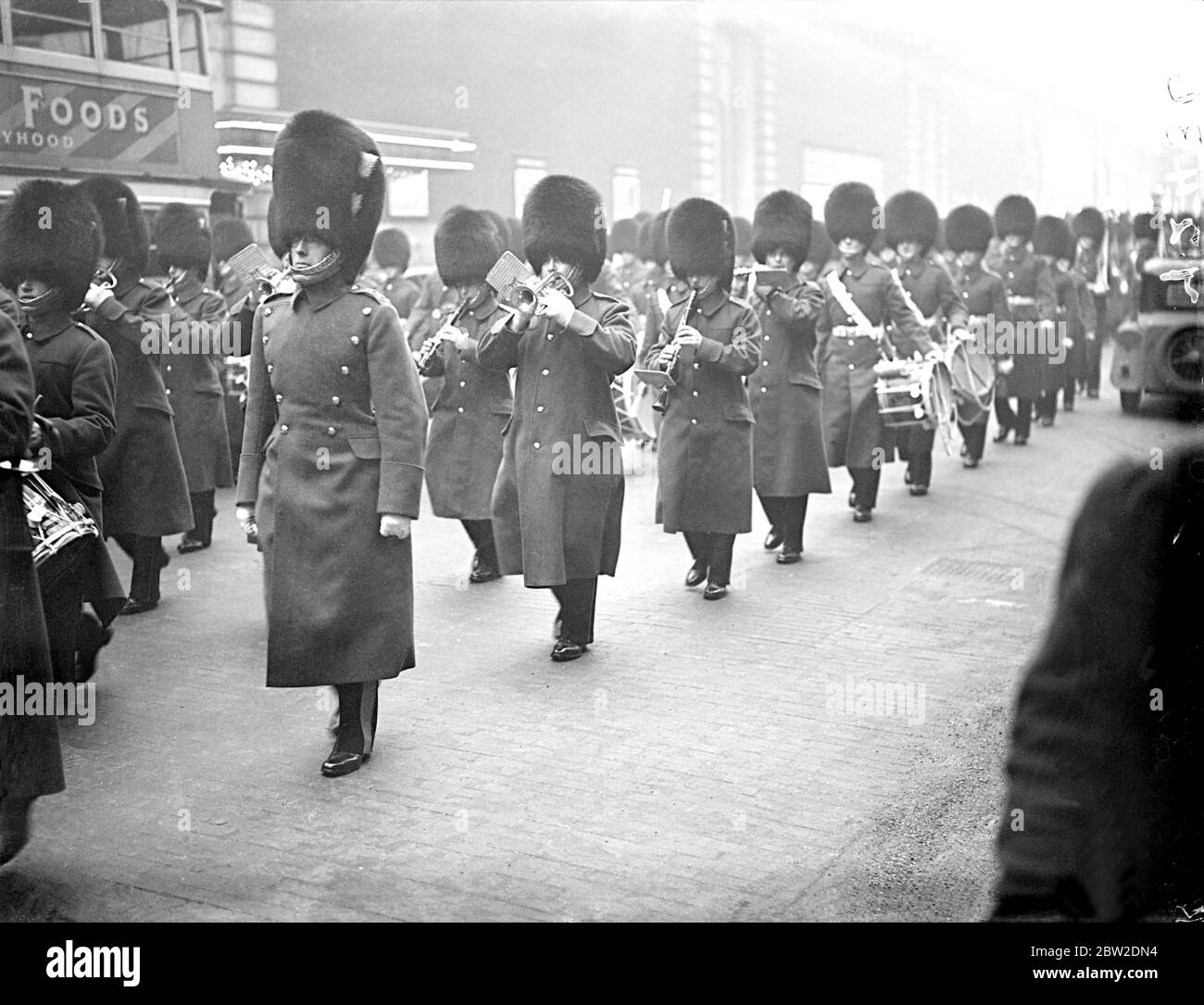 Welsh Guards neuer musikalischer Leiter verlässt die Band zum ersten Mal. Lieutenant T S Chandler, LRAM, ARCM, der neue Direktor für Musik, Welsh Guards, leitete die Welsh Guards Band zum ersten Mal beim Wachwechsel, im St. James's Palace. LT Chandler war früher Kapellmeister des Royal Tank Corps. Er folgt Major A Harris, MVO, LRAM, der in den Ruhestand geht, als musikalischer Leiter der Welsh Guards. Foto zeigt LT TS Chandler (im Vordergrund) auf dem Weg von Chelsea Kaserne zum St. James's Palace mit der Welsh Guards Band. Januar 1938 Stockfoto