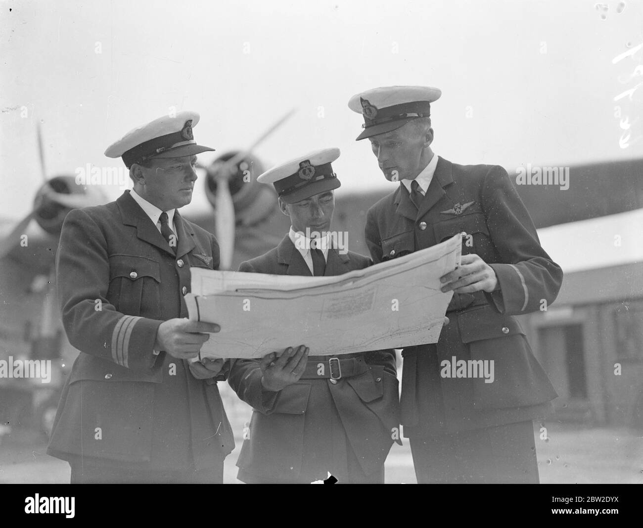 Von links nach rechts, Kapitän G.J Fowell; Herr B.A Moods, Funker; und First Officer C.F Elder Mitglieder des fliegenden Bootes bereiten sich in Southampton auf den zweiten experimentellen Atlantikflug vor, den die Cambria am 29. Juli durchführen soll. 23 Juli 1937 Stockfoto