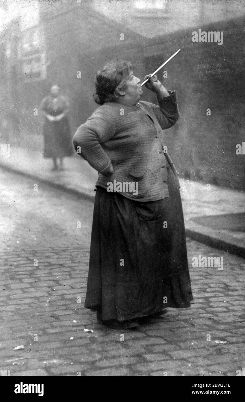 Mrs. Mary Smith weckt 1927 mit ihrem Peashoter die Hafenarbeiter von Limehouse, London. Ein längst verschwundener Job. Dieses sehr berühmte Foto von John Topham war das erste, das er jemals lizensiert hatte, und es veranlasste ihn, seine Karriere als Polizist aufzugeben und den Rest seines Lebens als großer Fotograf zu verbringen. Stockfoto
