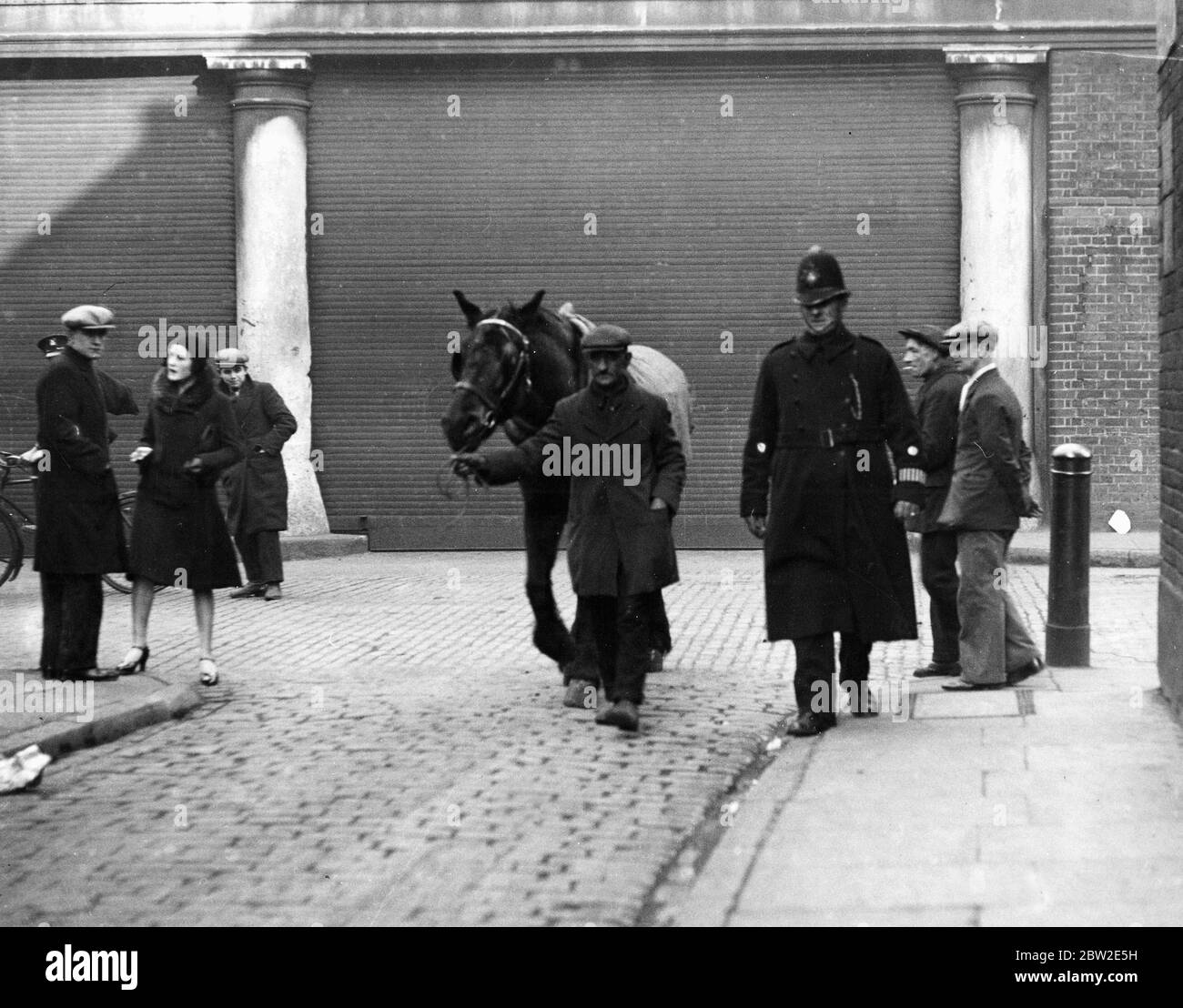 PC Dent und ein lahmes Pferd - wenn das Pferd nicht arbeitsfähig wäre, dann würde es sofort aus den Schächten des Wagens entfernt und zum TierPfund genommen werden. Der Fahrer würde natürlich zum Nick (Polizeistation) gebracht. East End von London. 1920er/1930er Jahre Stockfoto