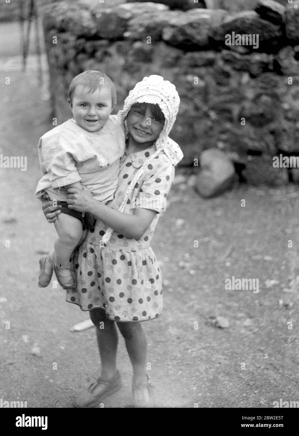 Mädchen, das ein Baby in den Armen hält. 1933 Stockfoto